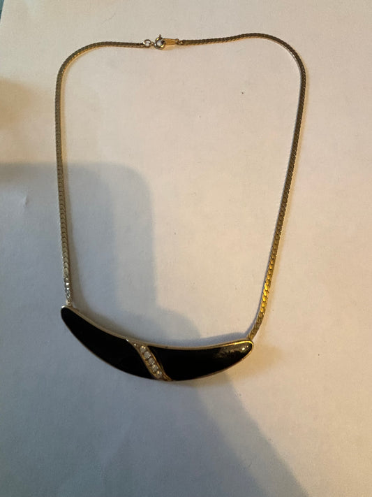 Flat gold metal necklace with curved black and diamante pendant