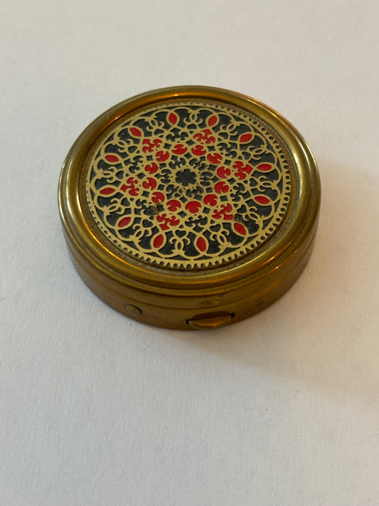 Round brass pill pot with red and gold patterned lid