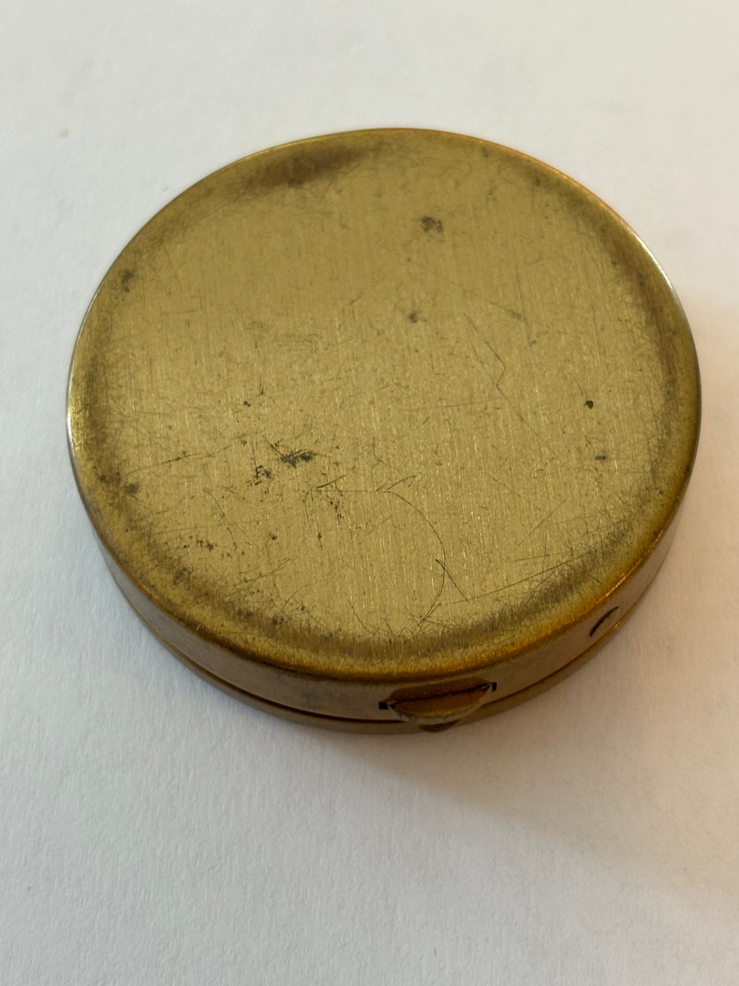 Round brass pill pot with red and gold patterned lid