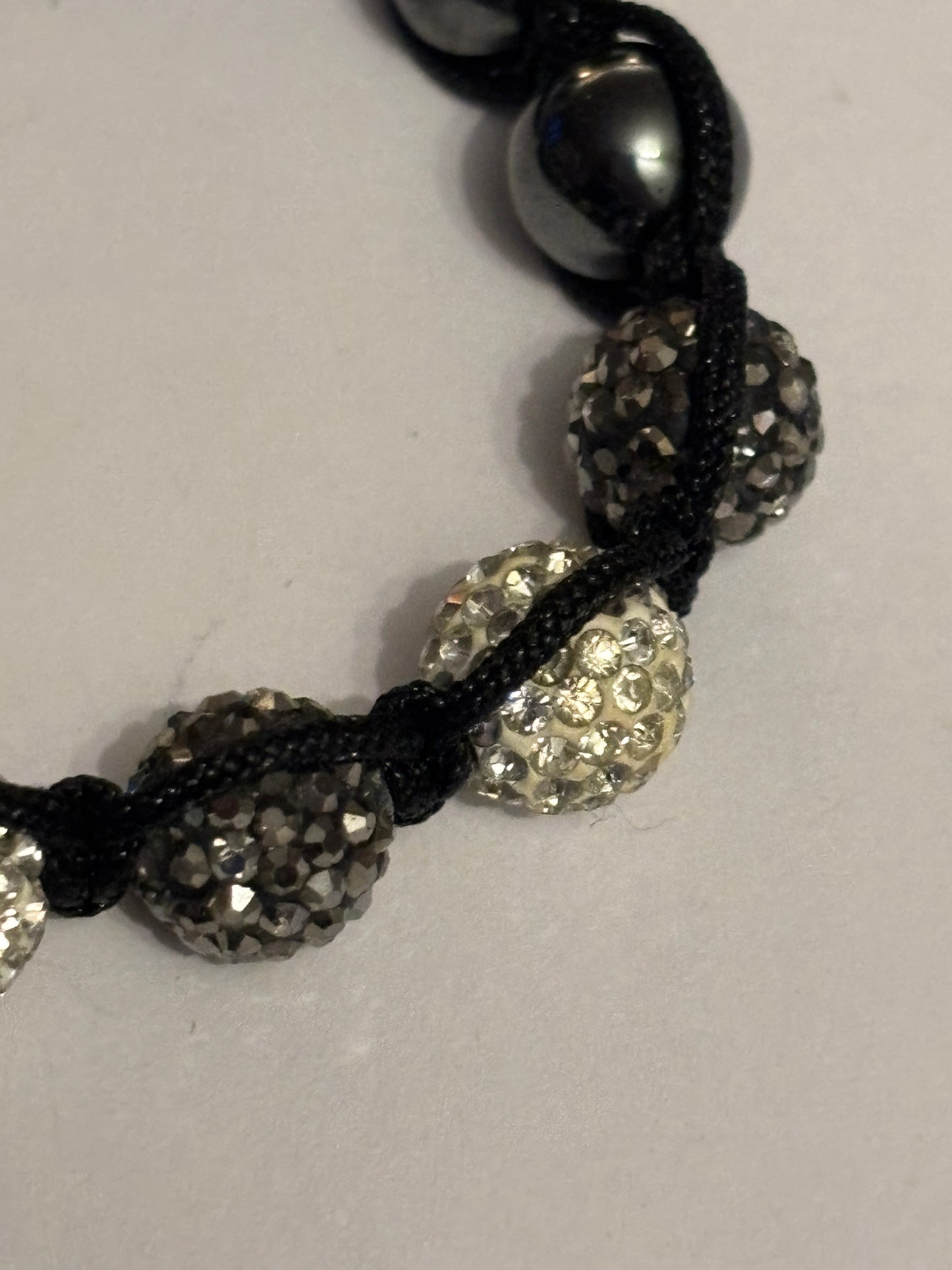 Black string friendship bracelet with silver and grey crystal beads