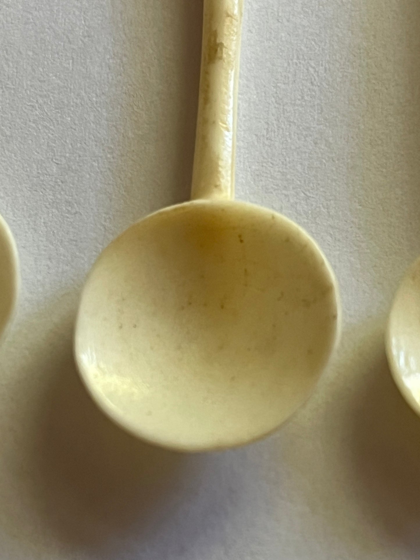 Set of small cream coloured elephant pattern cocktail sticks and spoons