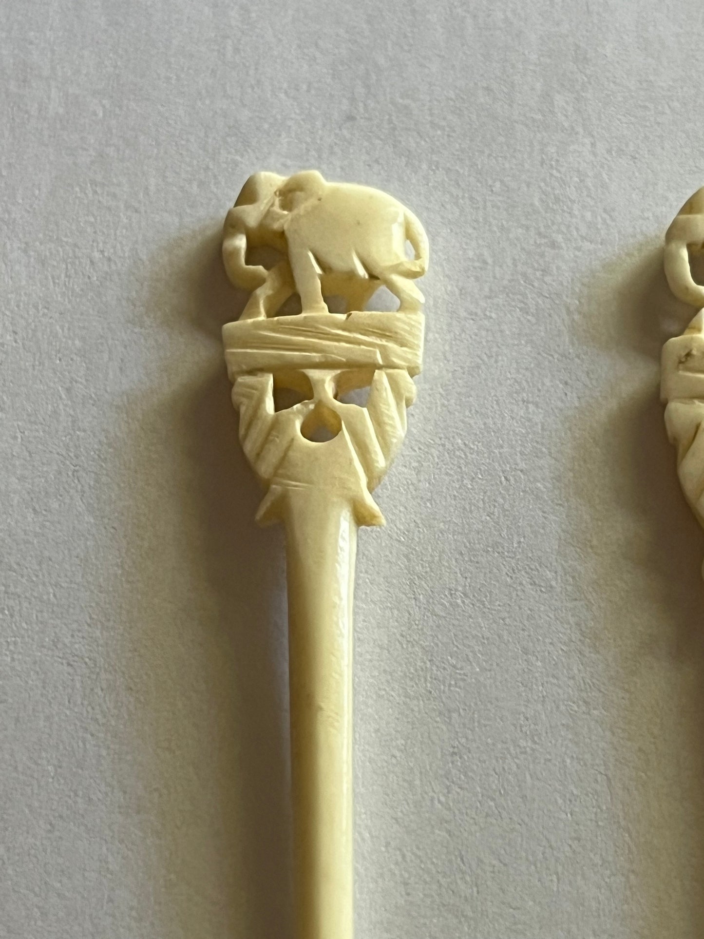 Set of small cream coloured elephant pattern cocktail sticks and spoons