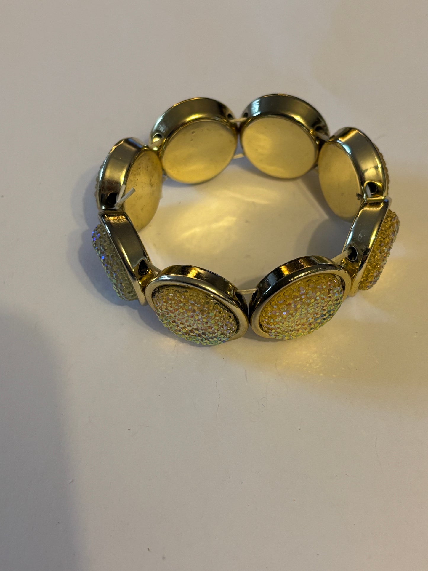 Light gold metal bracelet with round sparkly setting