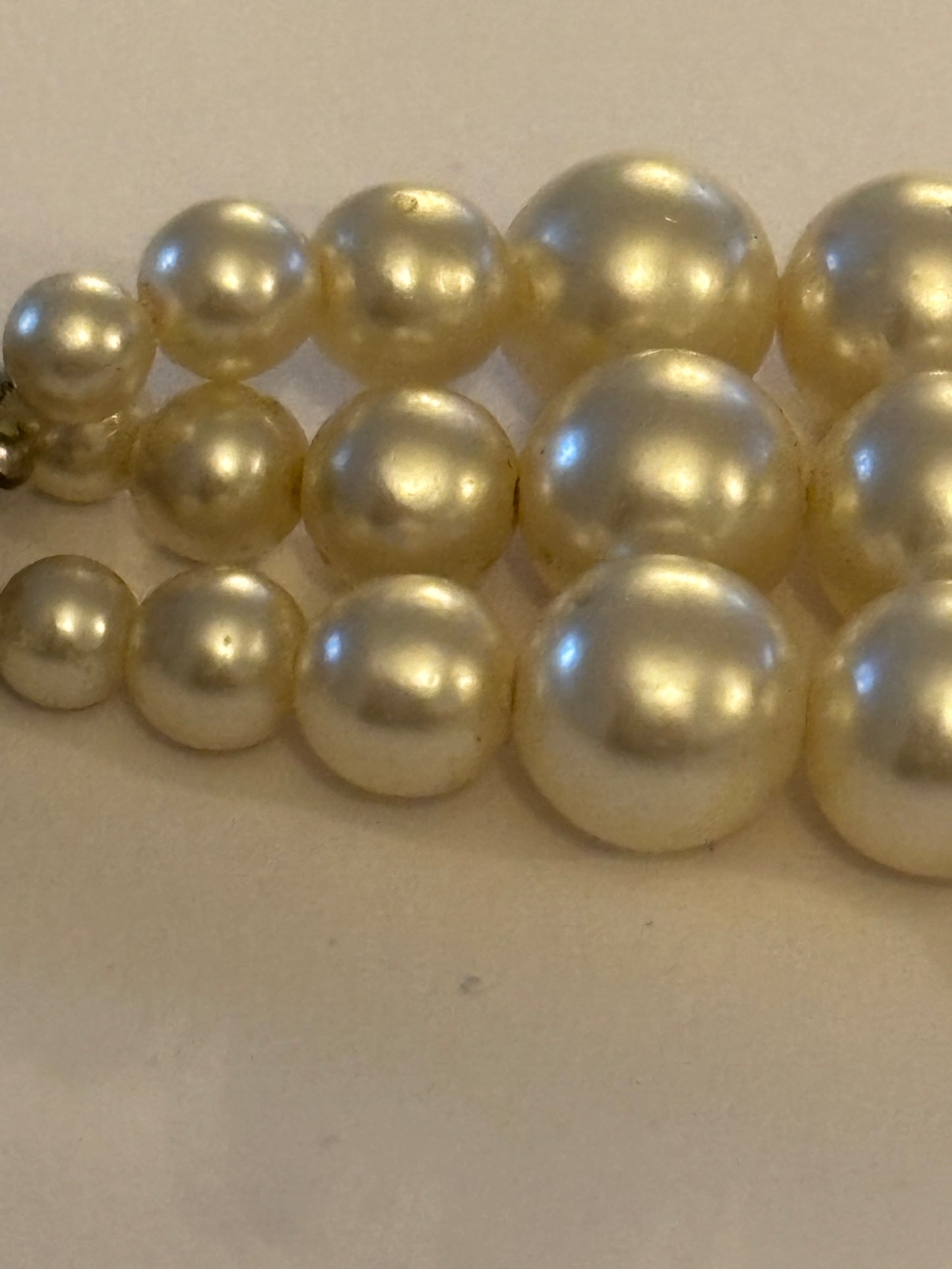 Triple tier faux pearl necklace with ornate round silver clasp