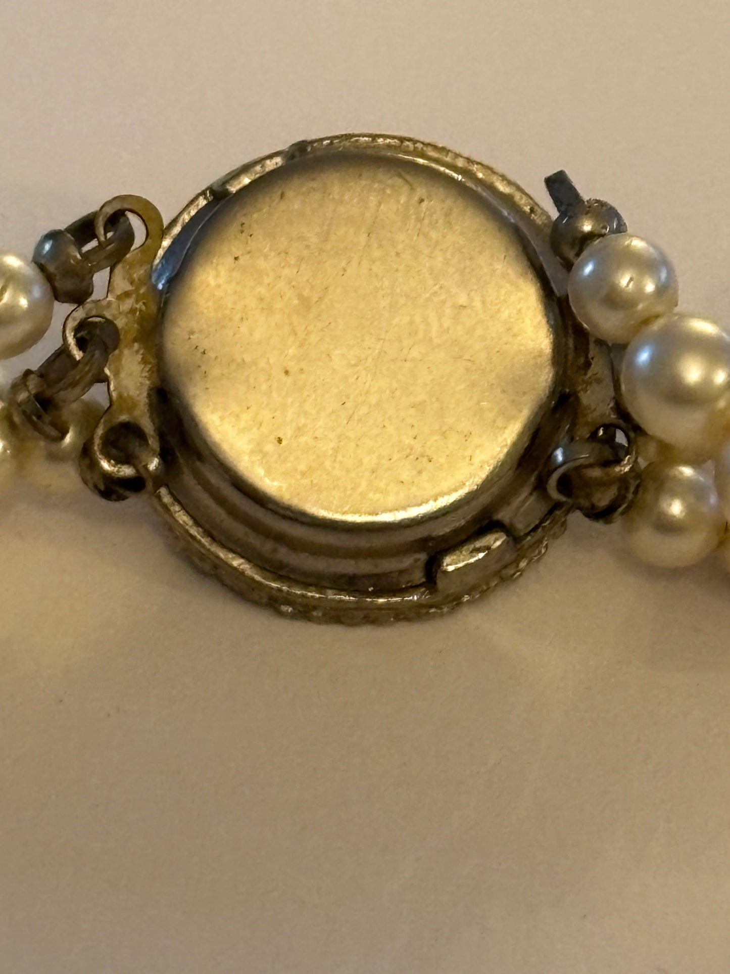 Triple tier faux pearl necklace with ornate round silver clasp