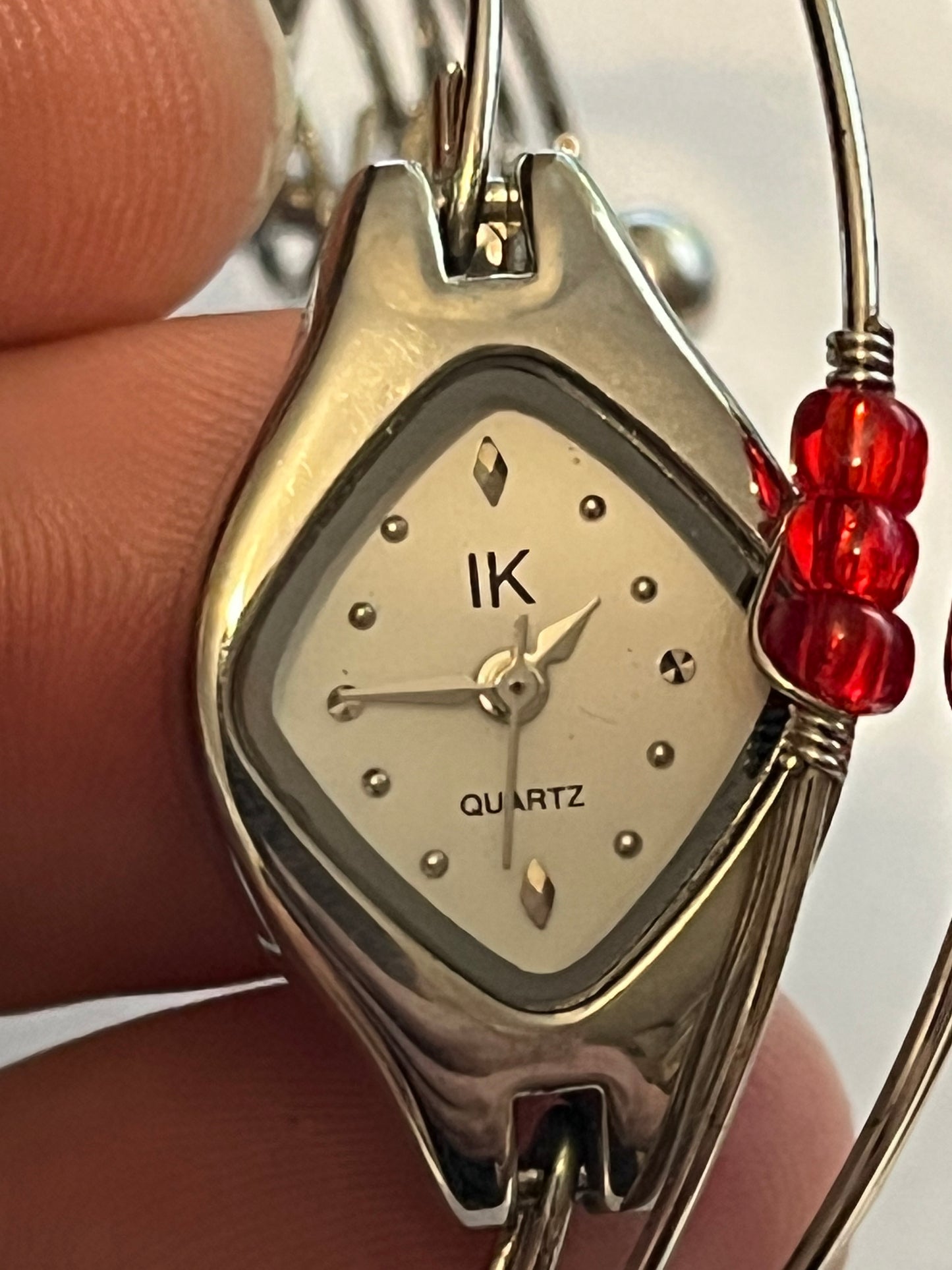 Unusual multi wire bangle with read beads and a watch