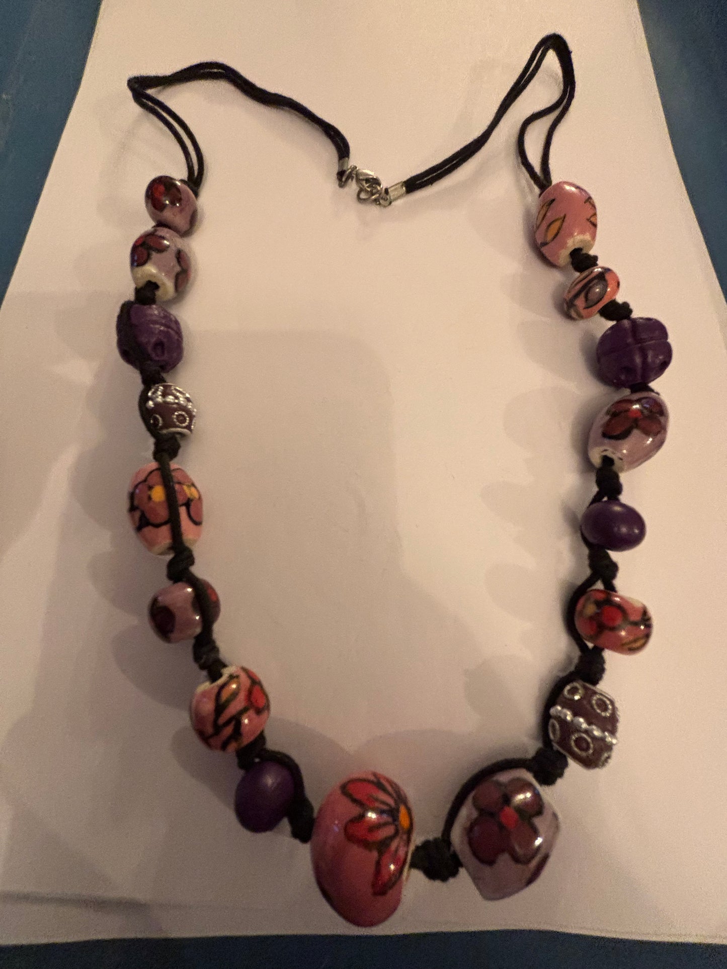 Black necklace with painted pink and purple ceramic beads