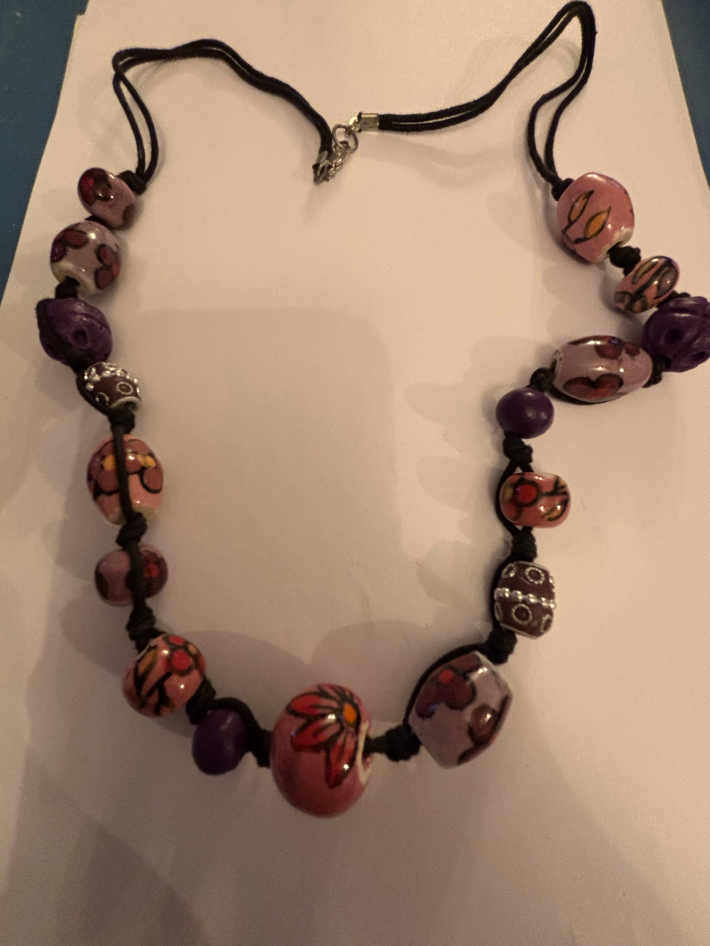 Black necklace with painted pink and purple ceramic beads