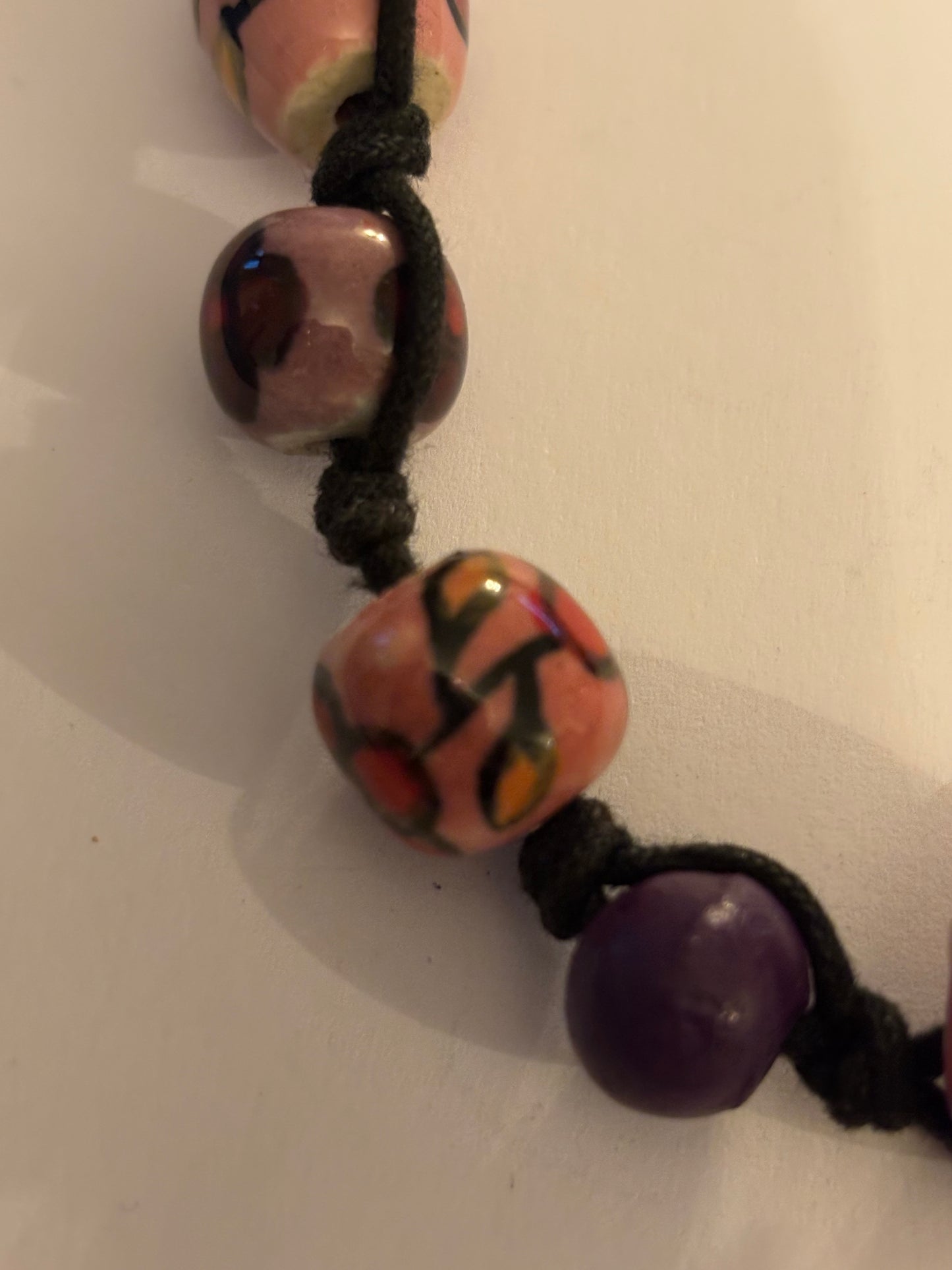 Black necklace with painted pink and purple ceramic beads