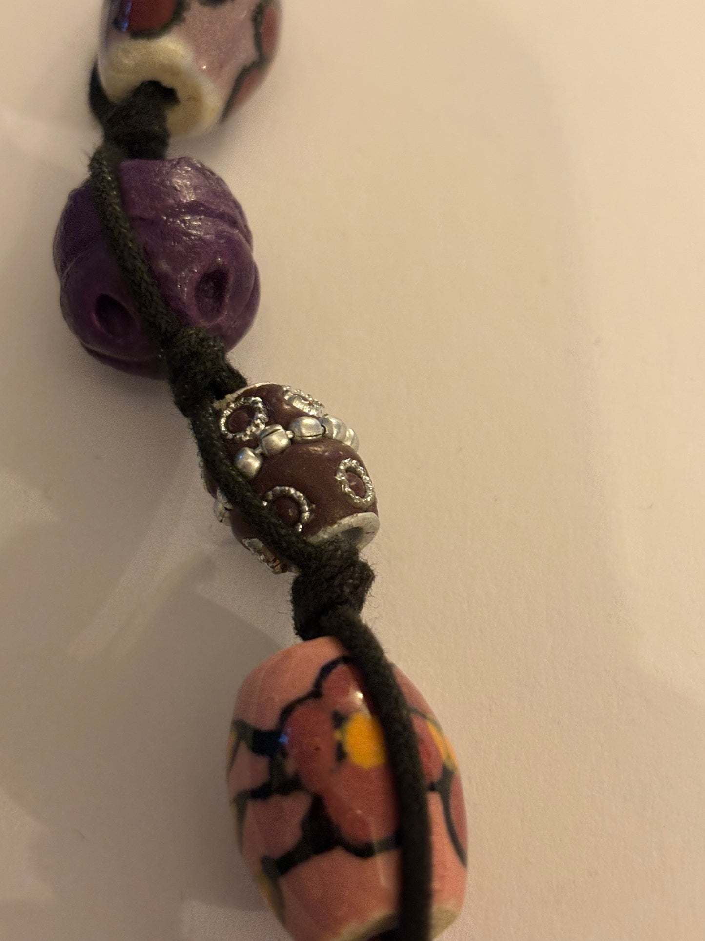 Black necklace with painted pink and purple ceramic beads