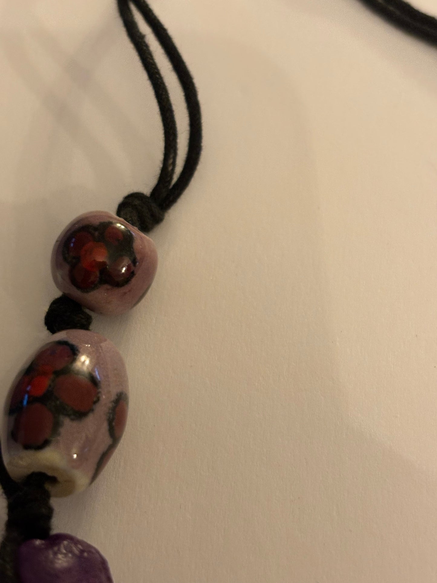 Black necklace with painted pink and purple ceramic beads