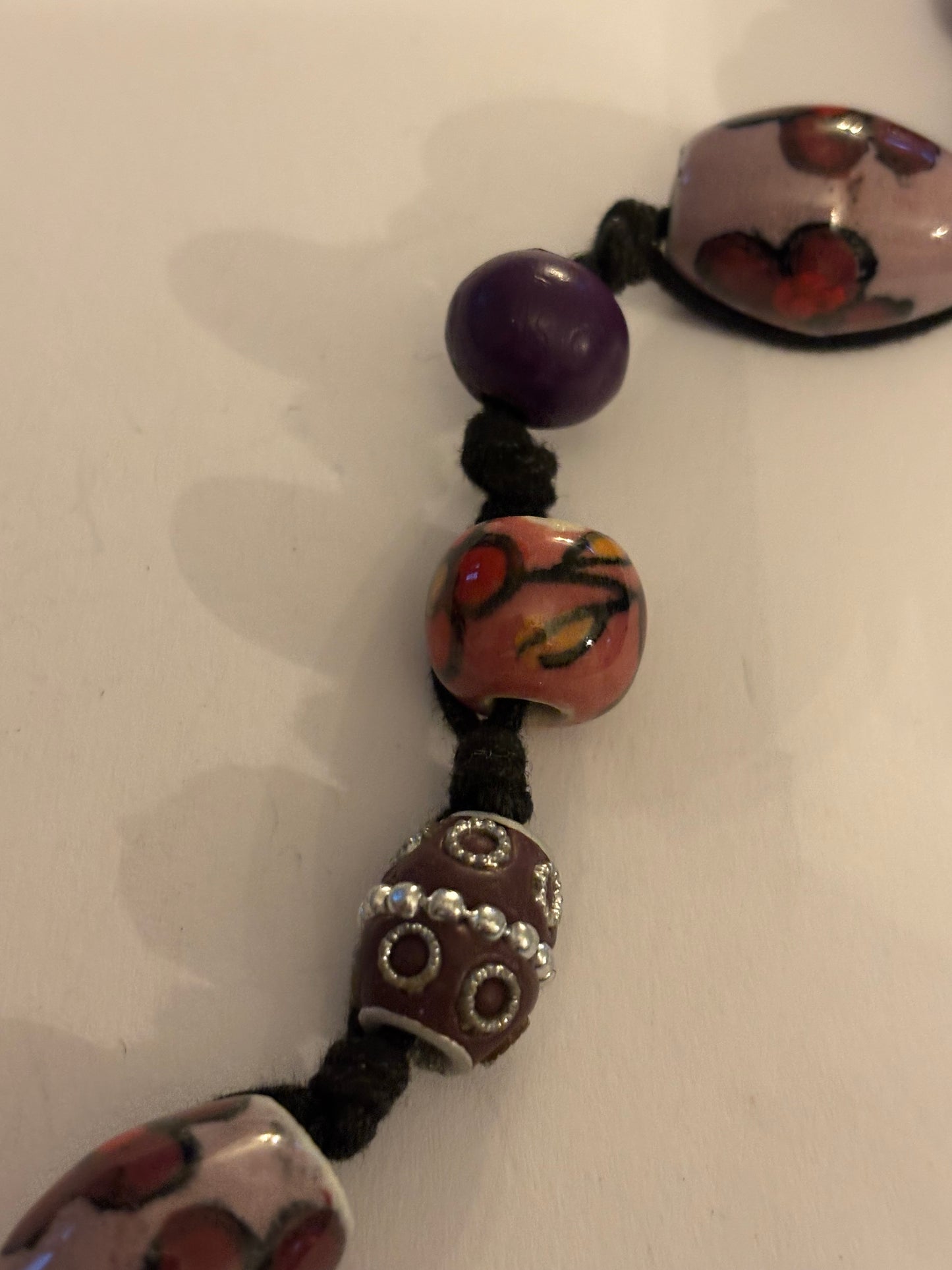 Black necklace with painted pink and purple ceramic beads