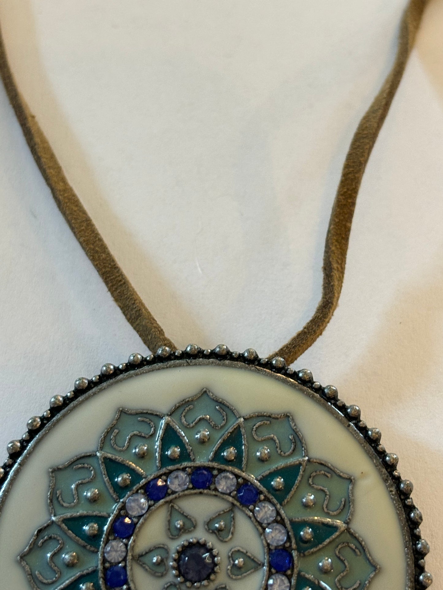 Light brown leather necklace with large round blue and white enamel pendant