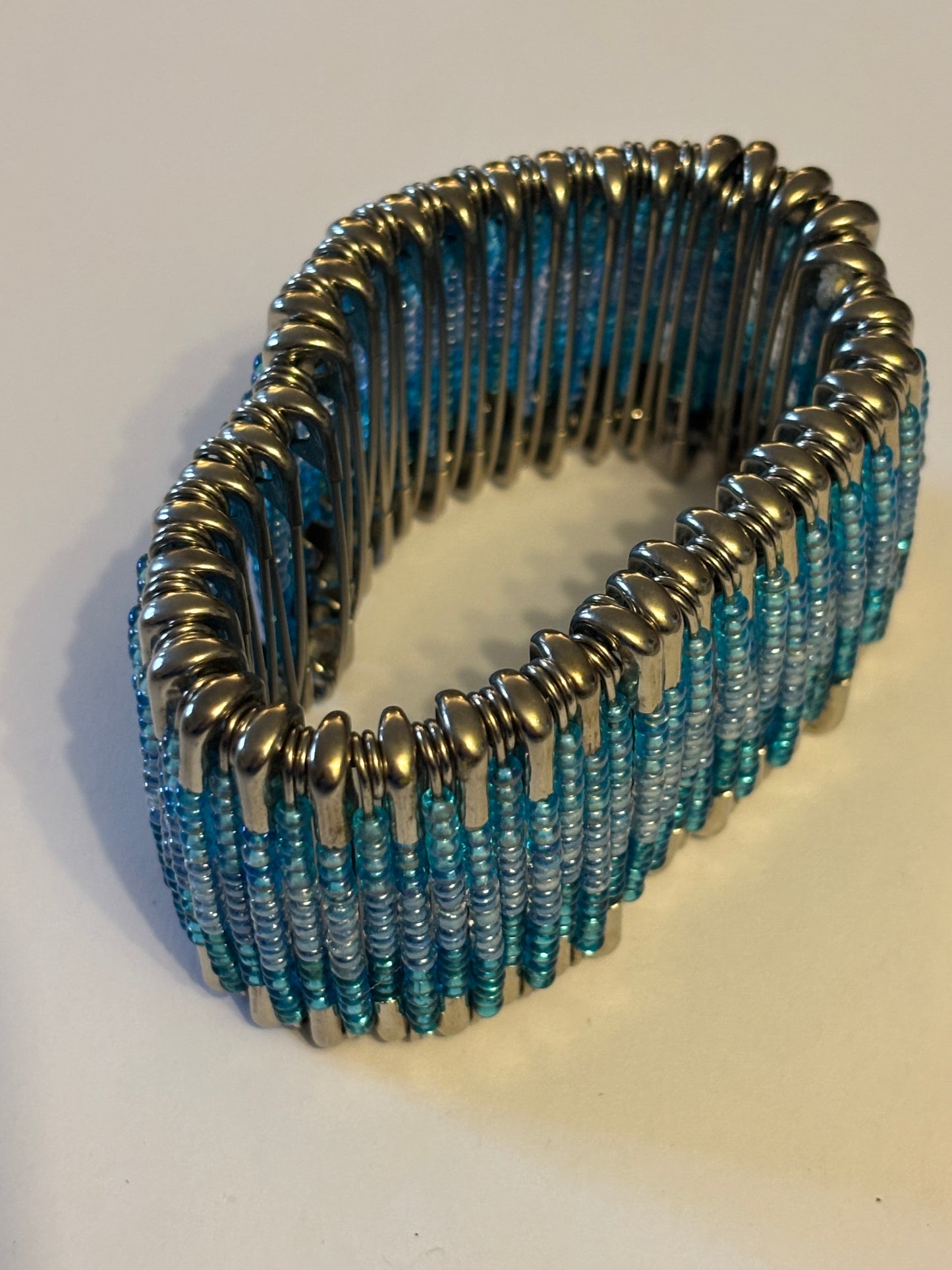 Wide stretch bracelet with rows of tiny blue beads capped with silver