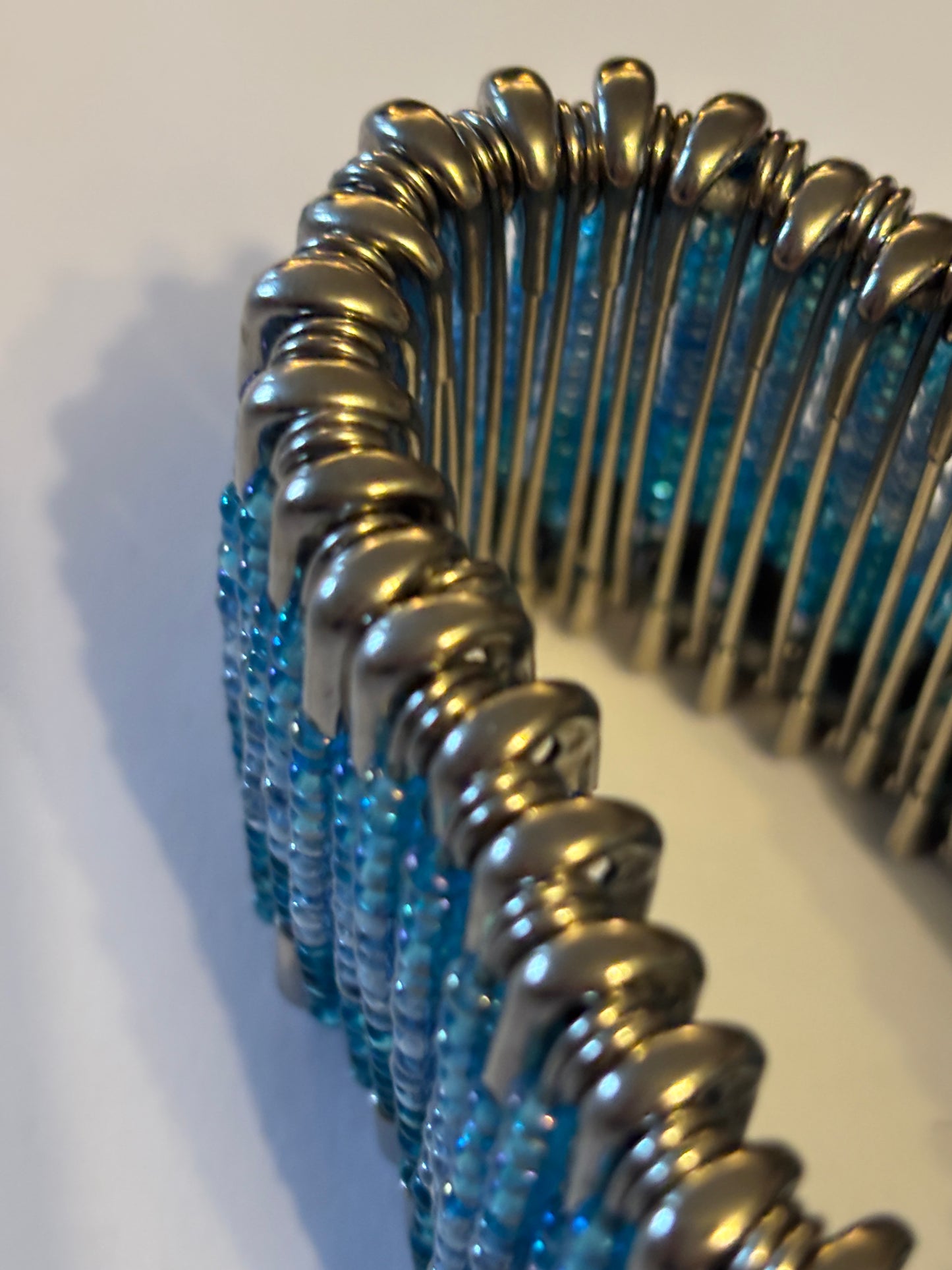 Wide stretch bracelet with rows of tiny blue beads capped with silver