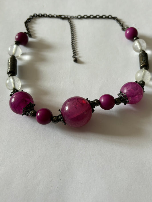 Ornate purple and clear beads on a dark metal necklace