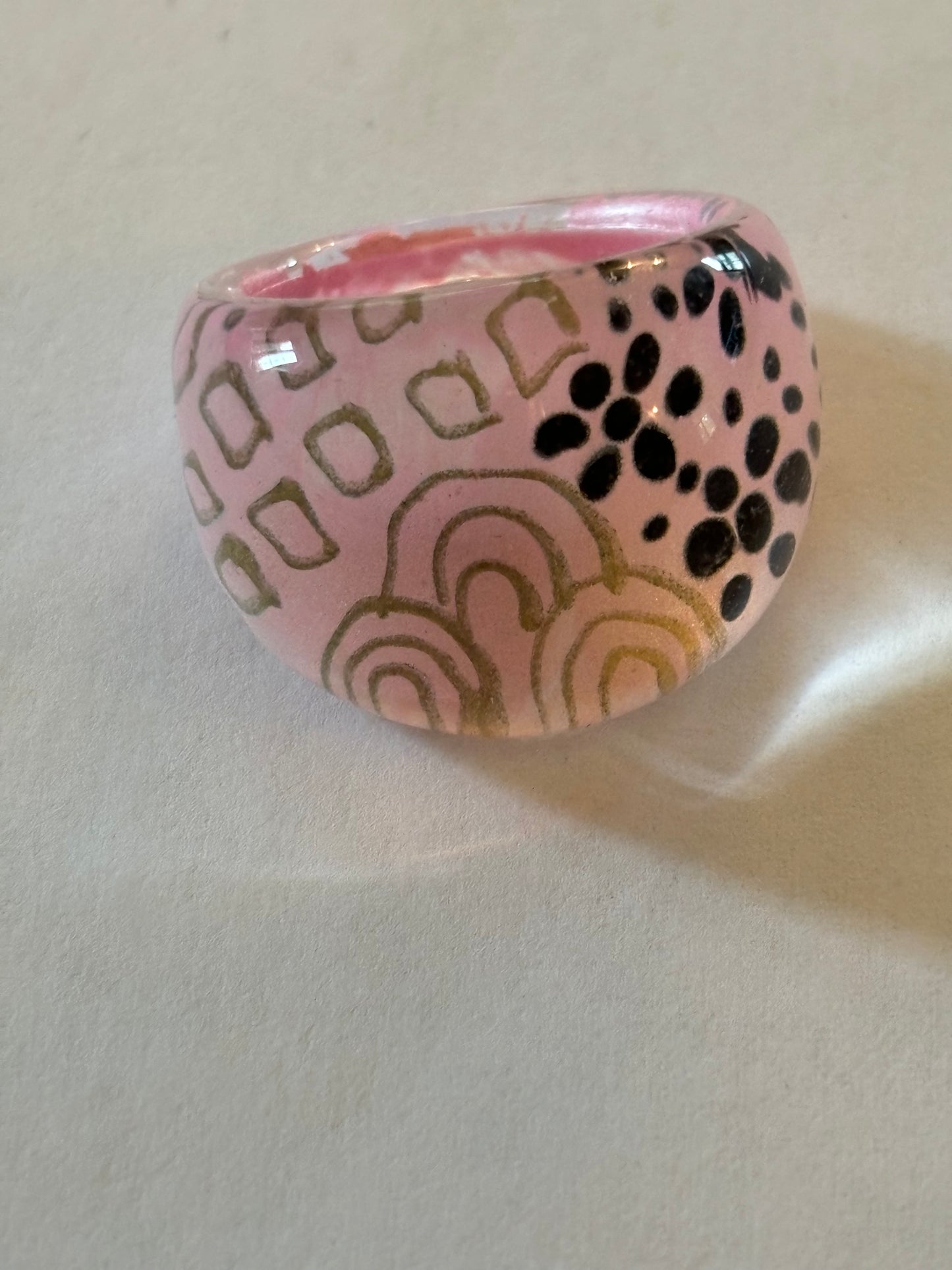 resin/glassy ring clear with a pink patterned background