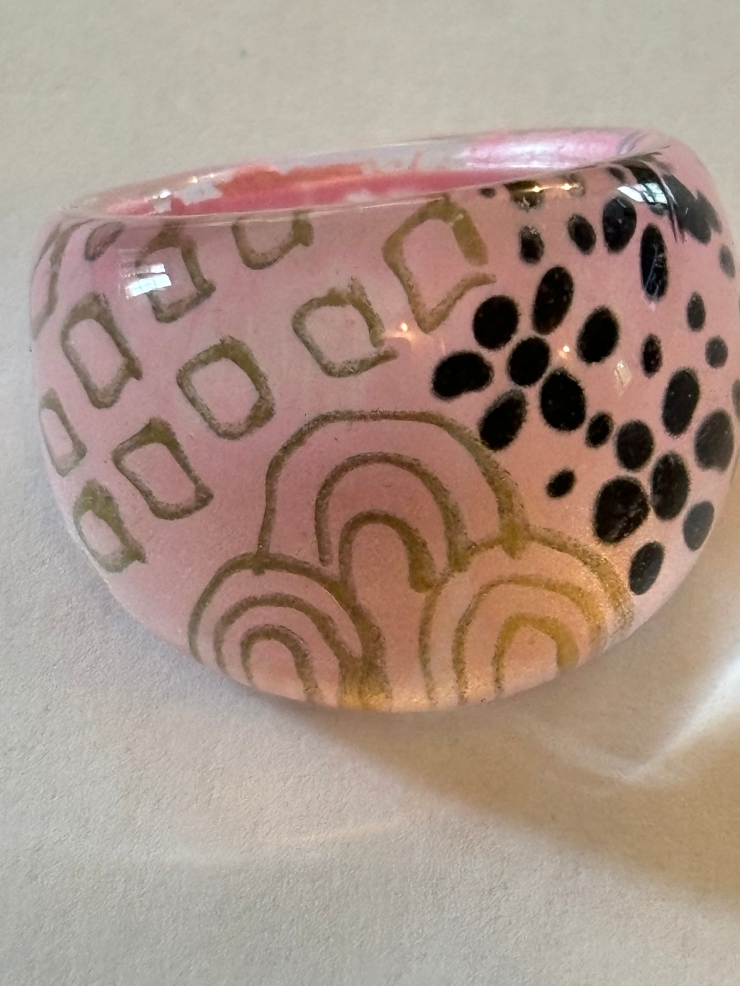 resin/glassy ring clear with a pink patterned background