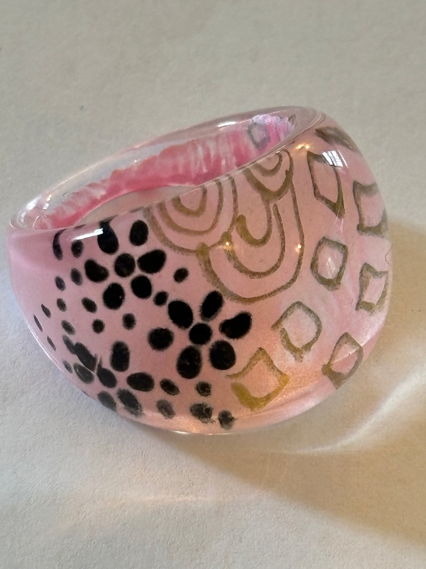 resin/glassy ring clear with a pink patterned background