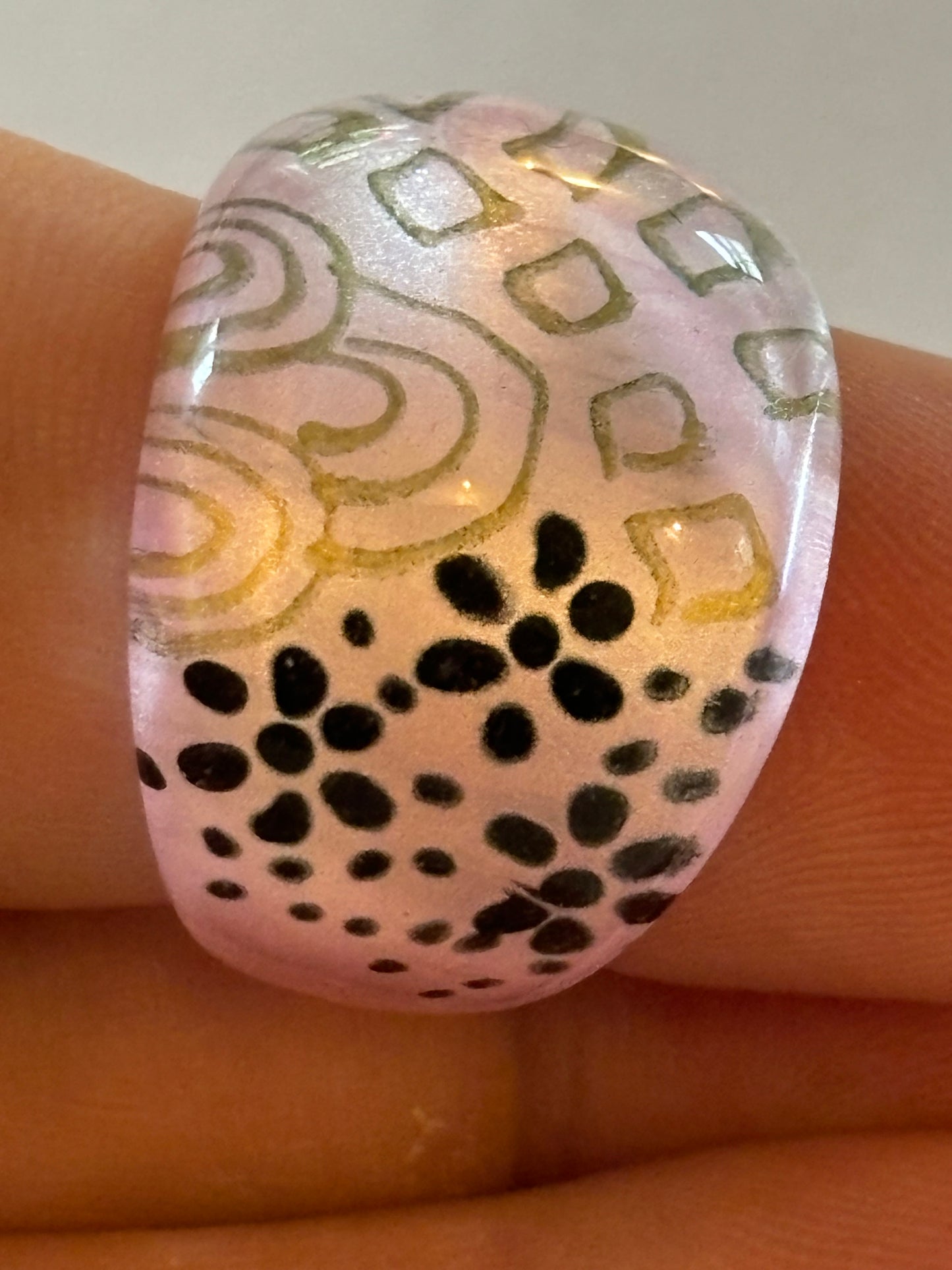 resin/glassy ring clear with a pink patterned background