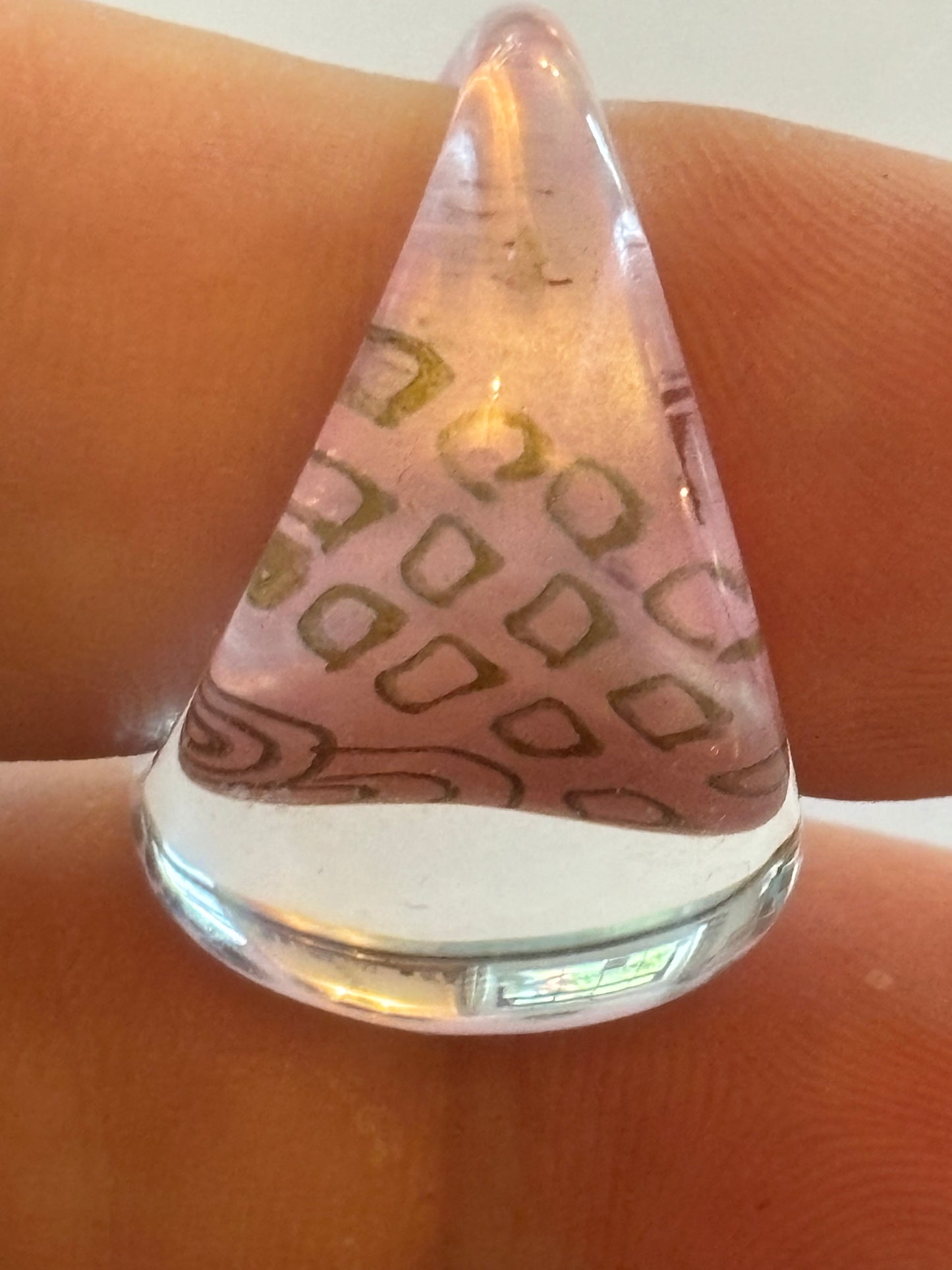 resin/glassy ring clear with a pink patterned background