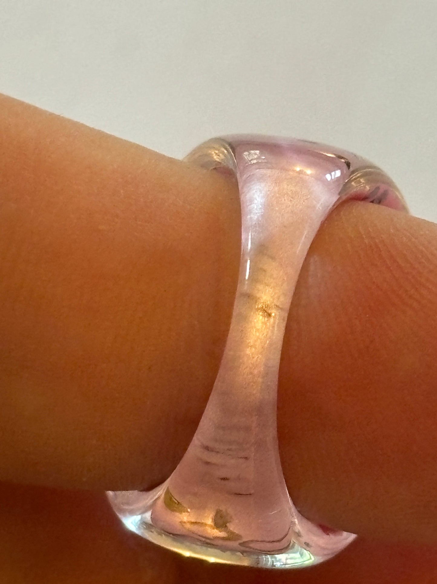 resin/glassy ring clear with a pink patterned background