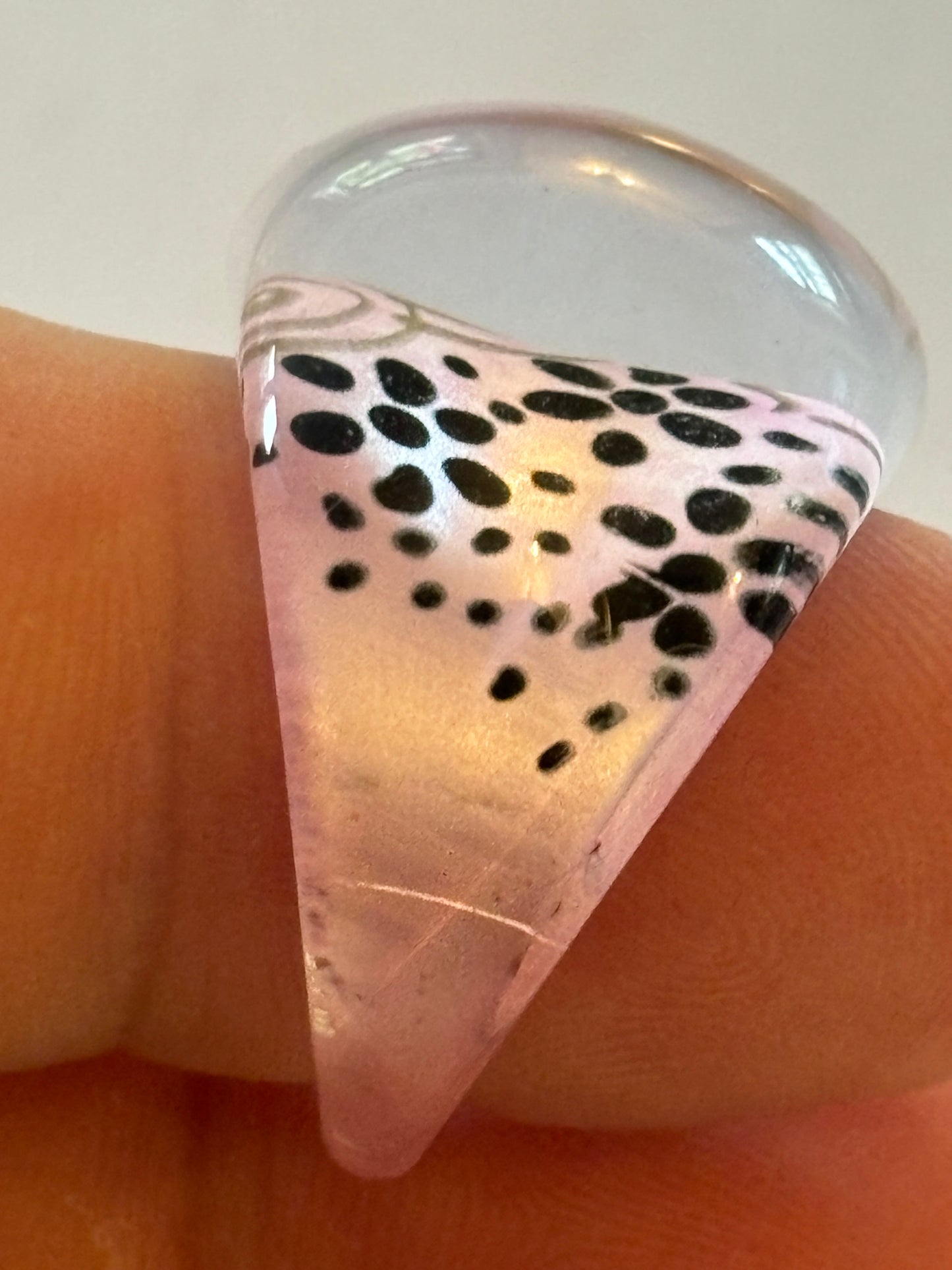 resin/glassy ring clear with a pink patterned background