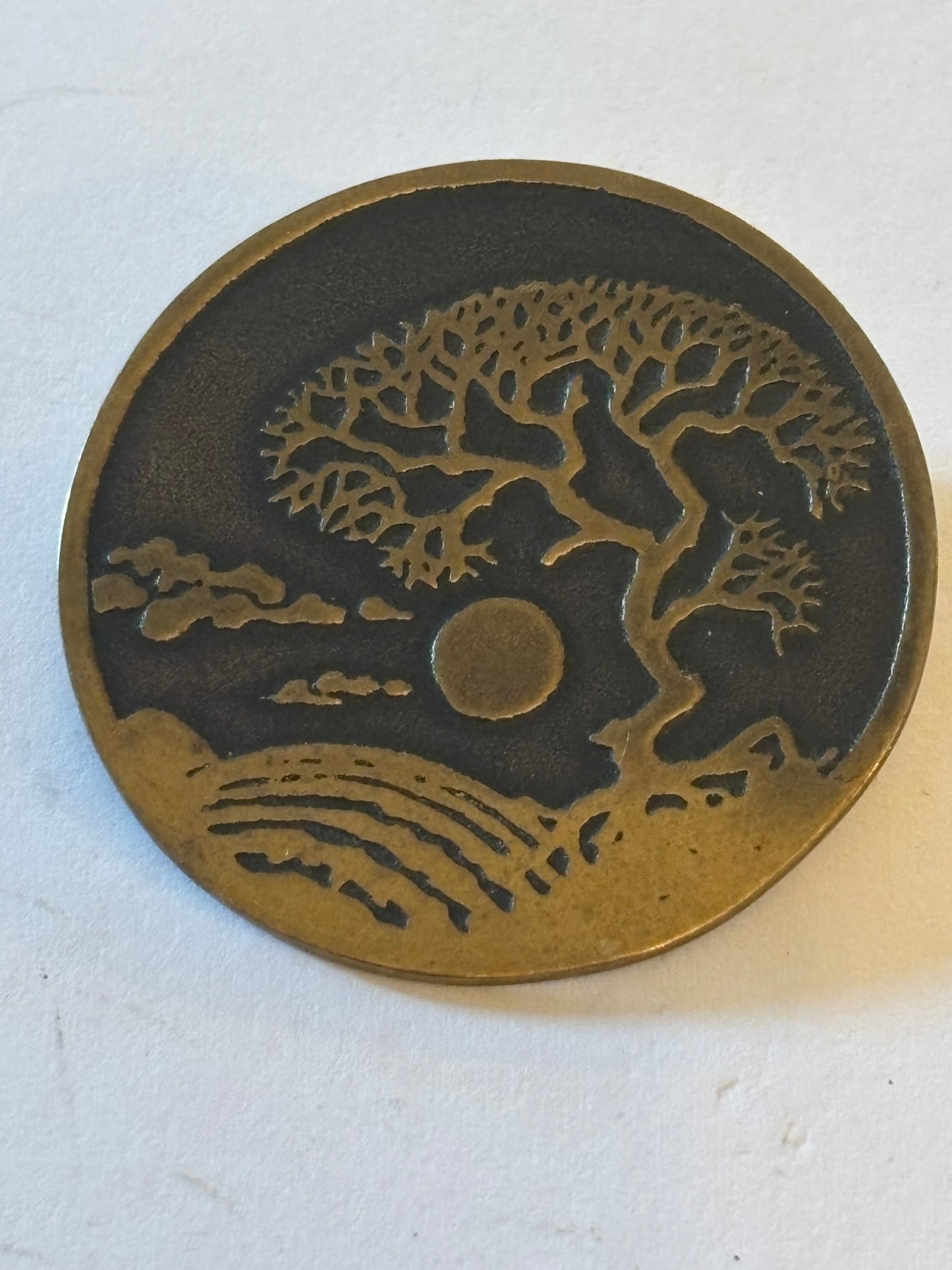 Round gold and black brooch with eastern tree design