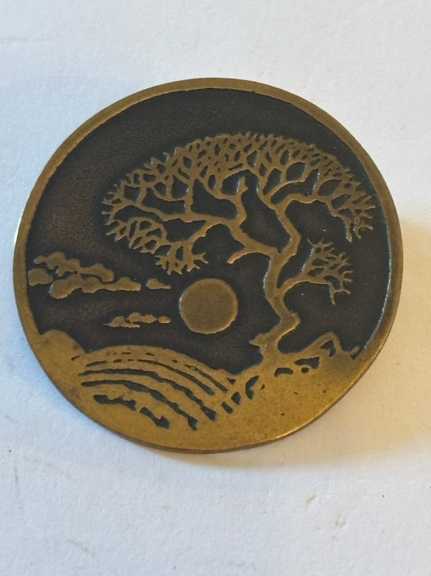 Round gold and black brooch with eastern tree design