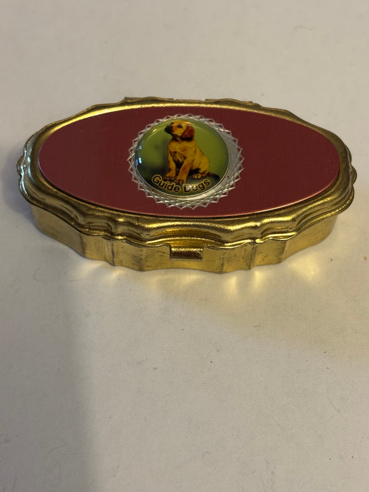 Small decorative gold pillbox with guide dog puppy