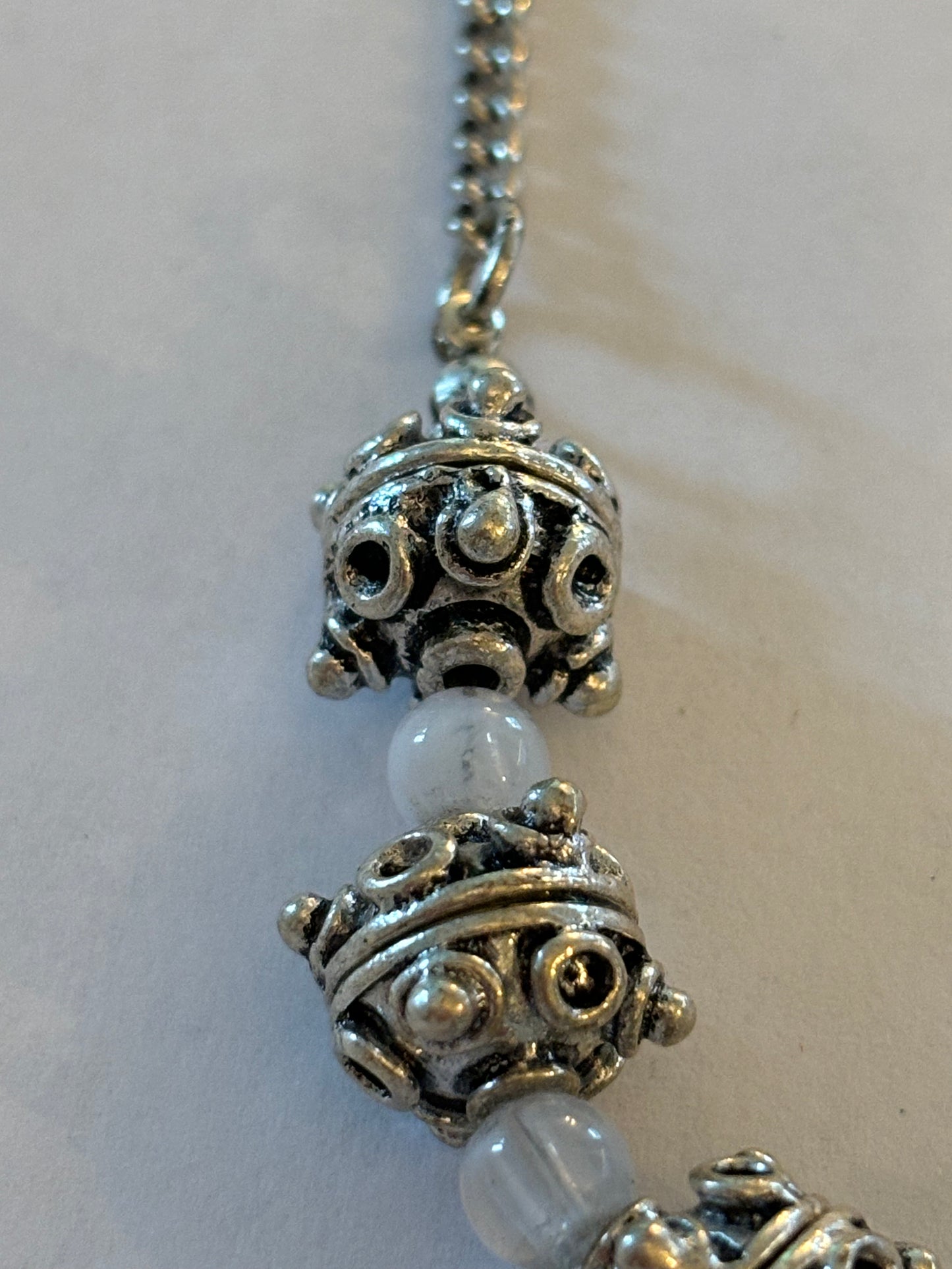 Bright silver ornate bead necklace with cloudy white spacers