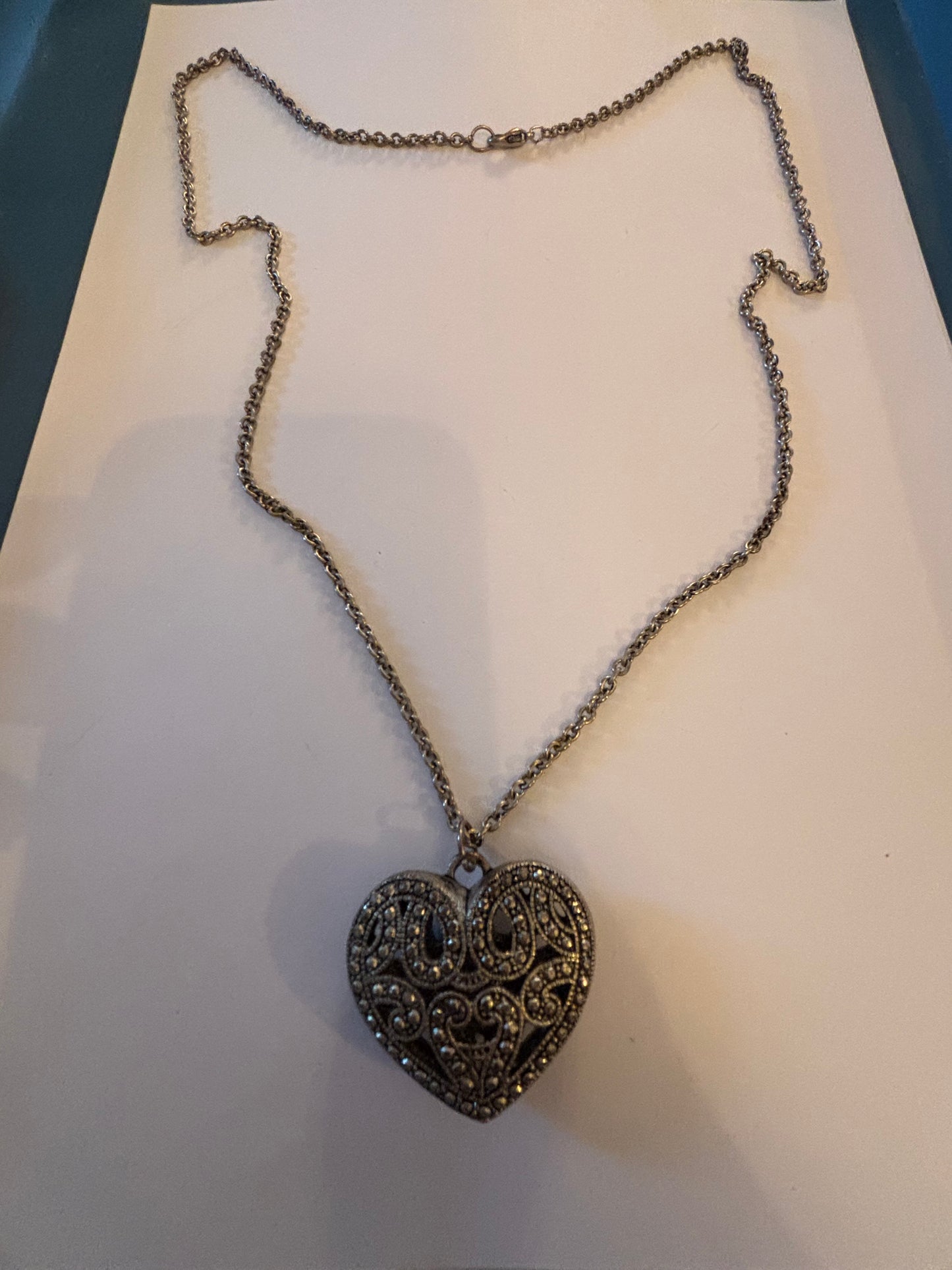 Long silver necklace with ornate 3D heart pendant