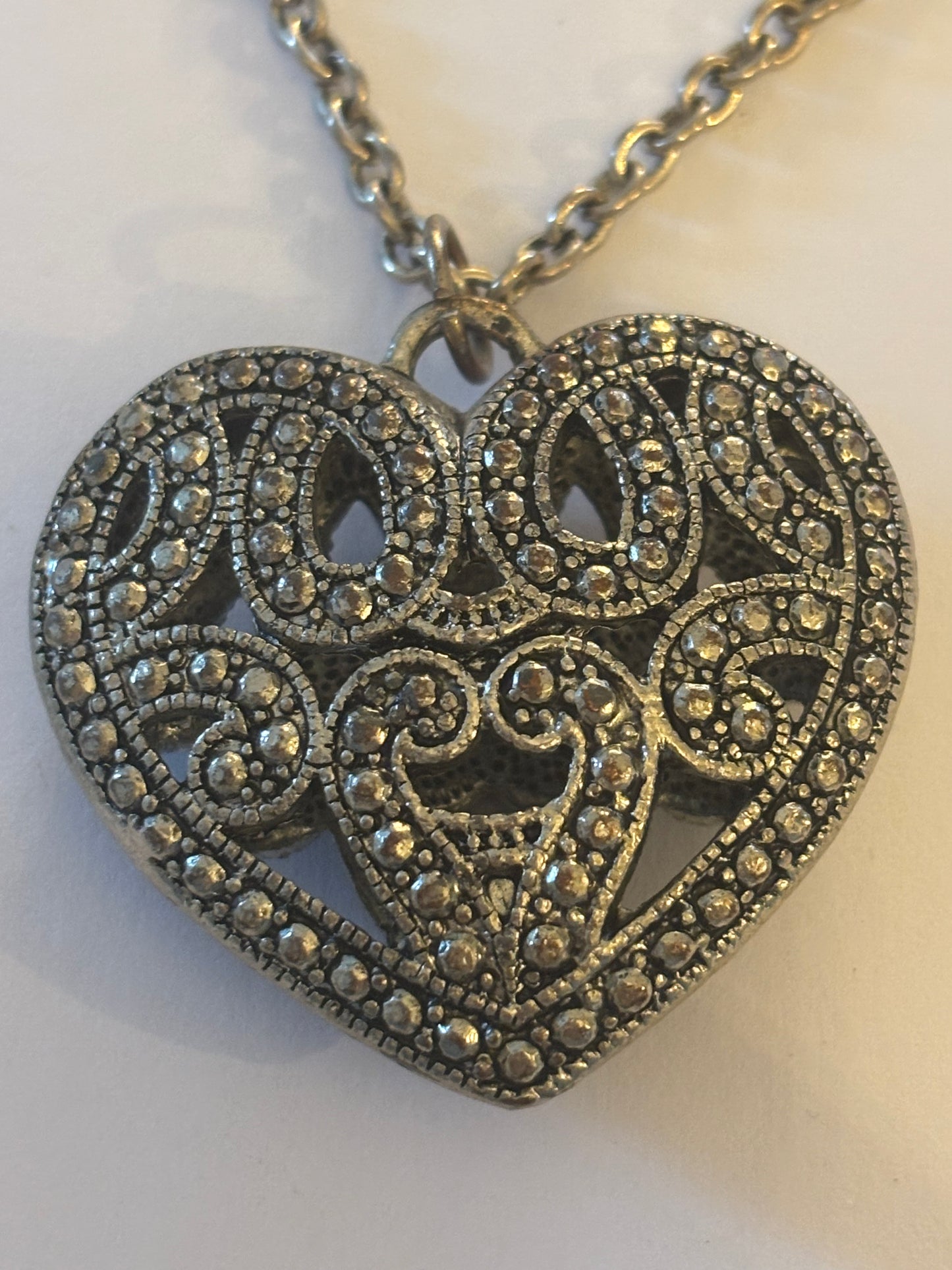 Long silver necklace with ornate 3D heart pendant