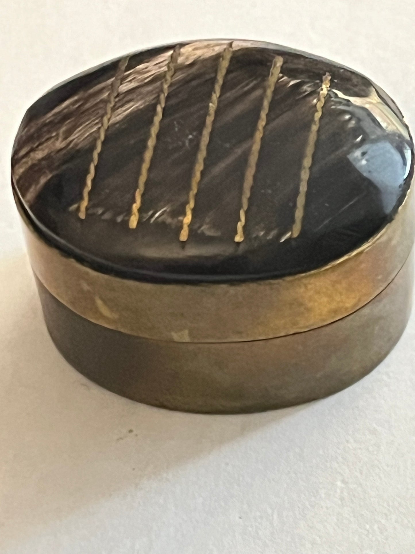 Small oval brass pill pot with black and white mineral top