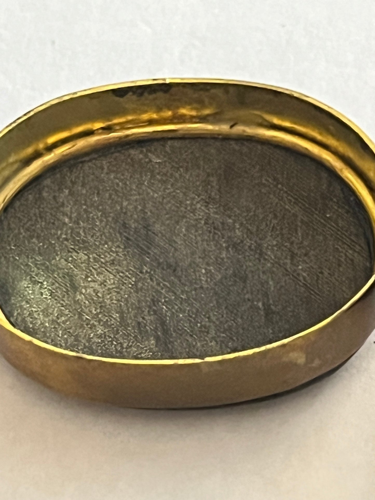 Small oval brass pill pot with black and white mineral top