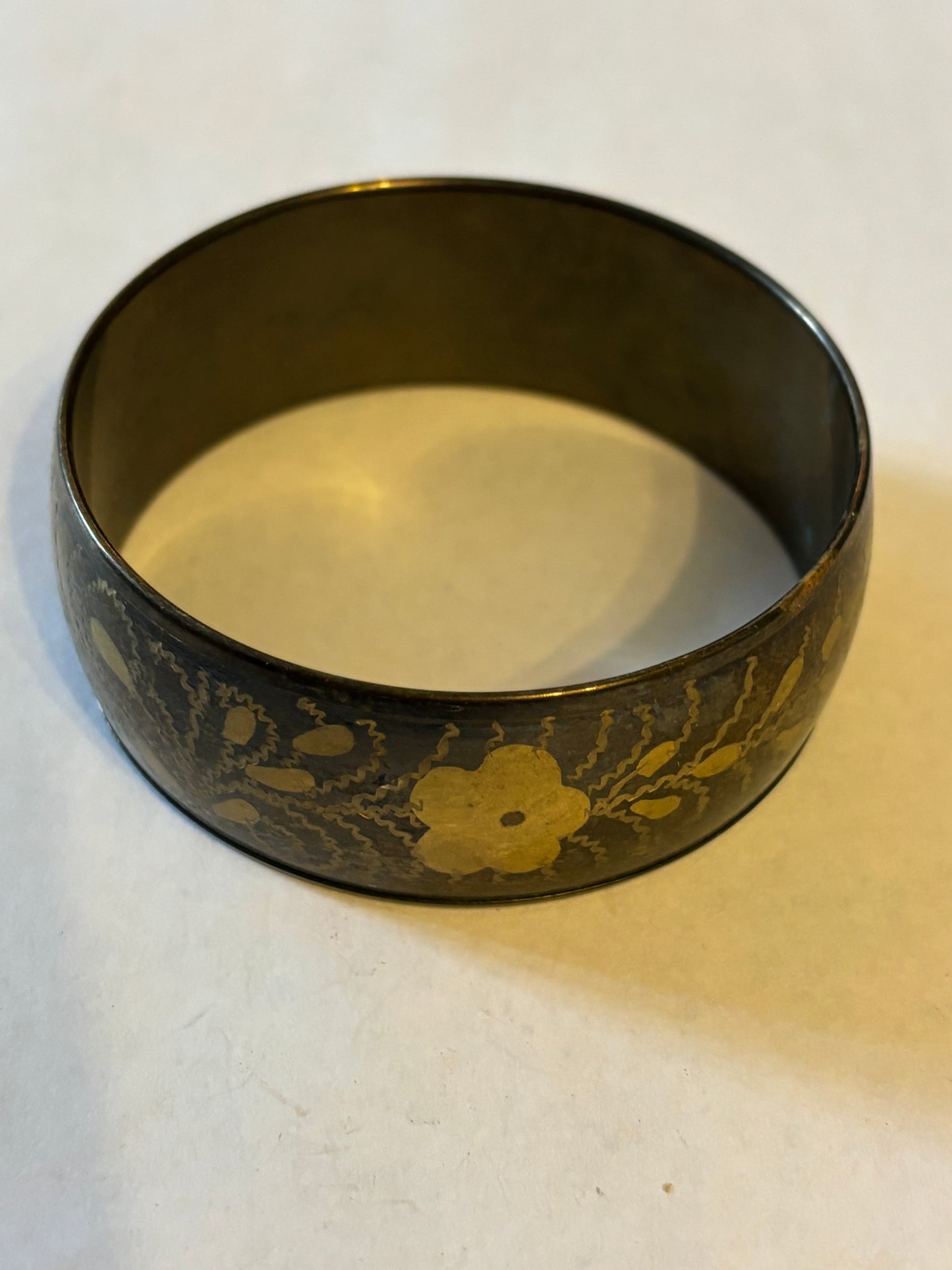 Dark metal bangle with gold flower pattern