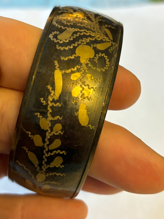 Dark metal bangle with gold flower pattern