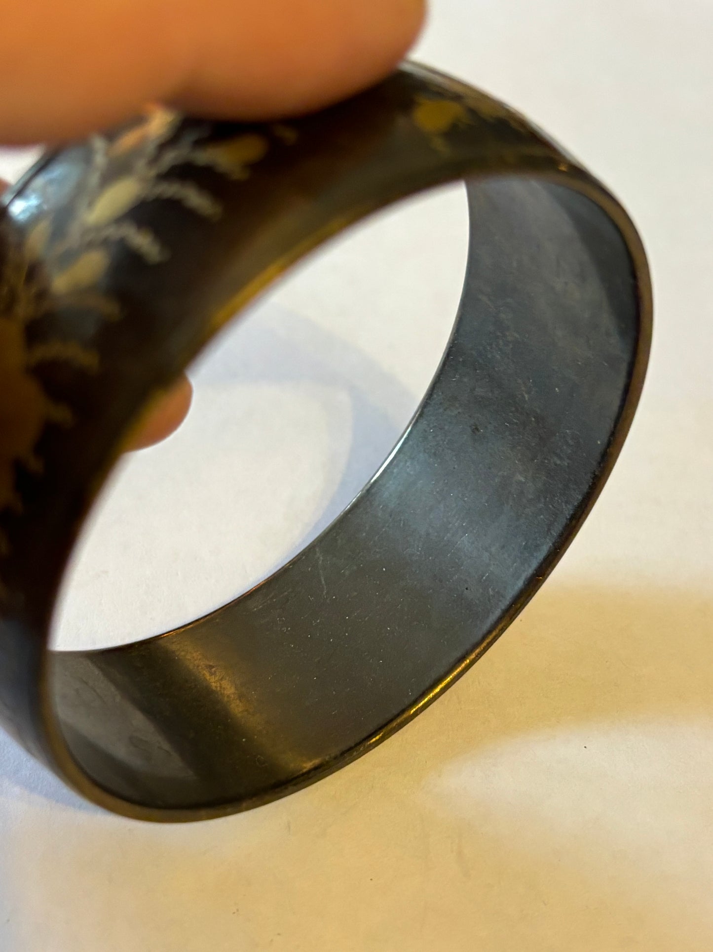 Dark metal bangle with gold flower pattern