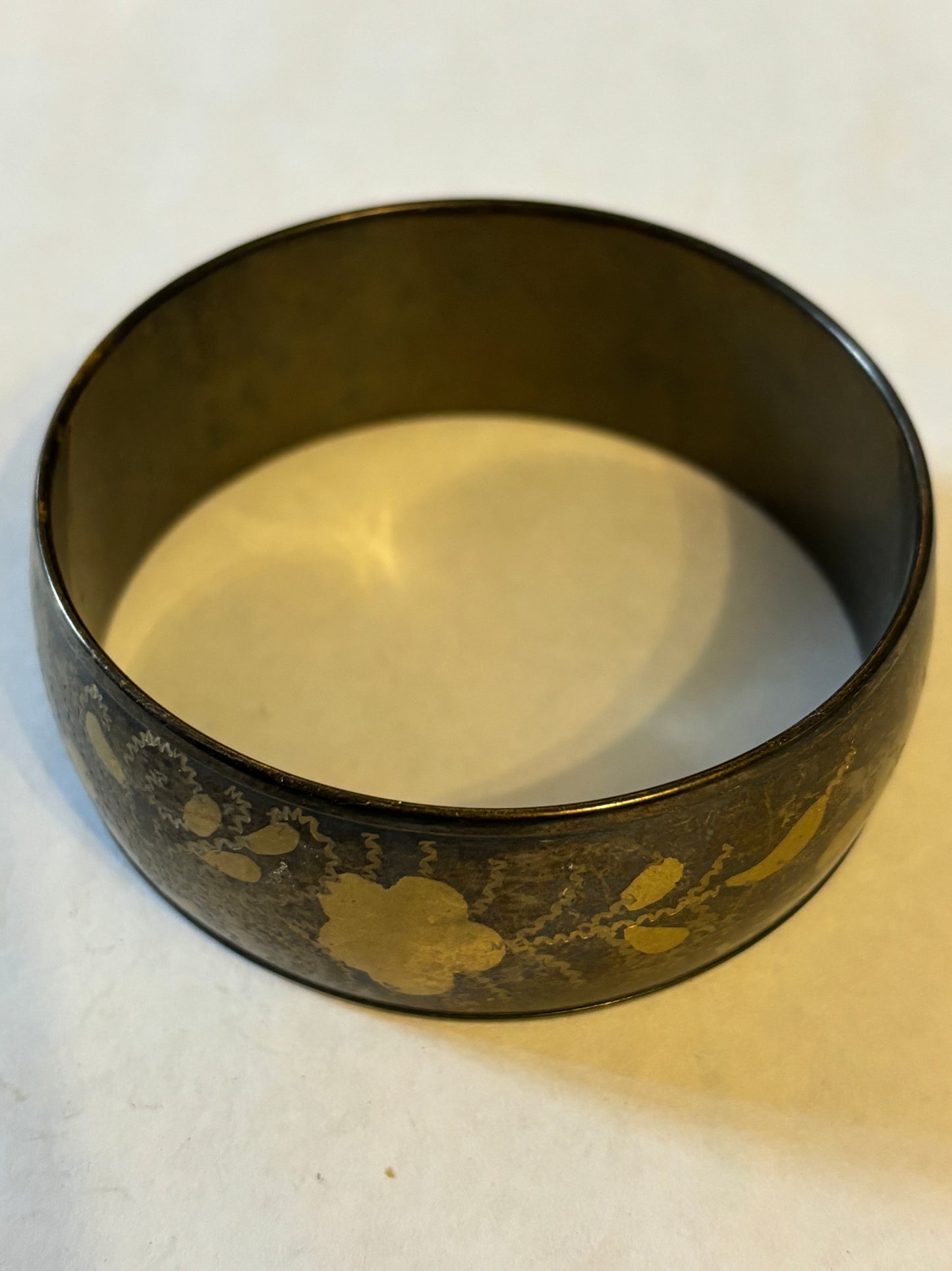 Dark metal bangle with gold flower pattern