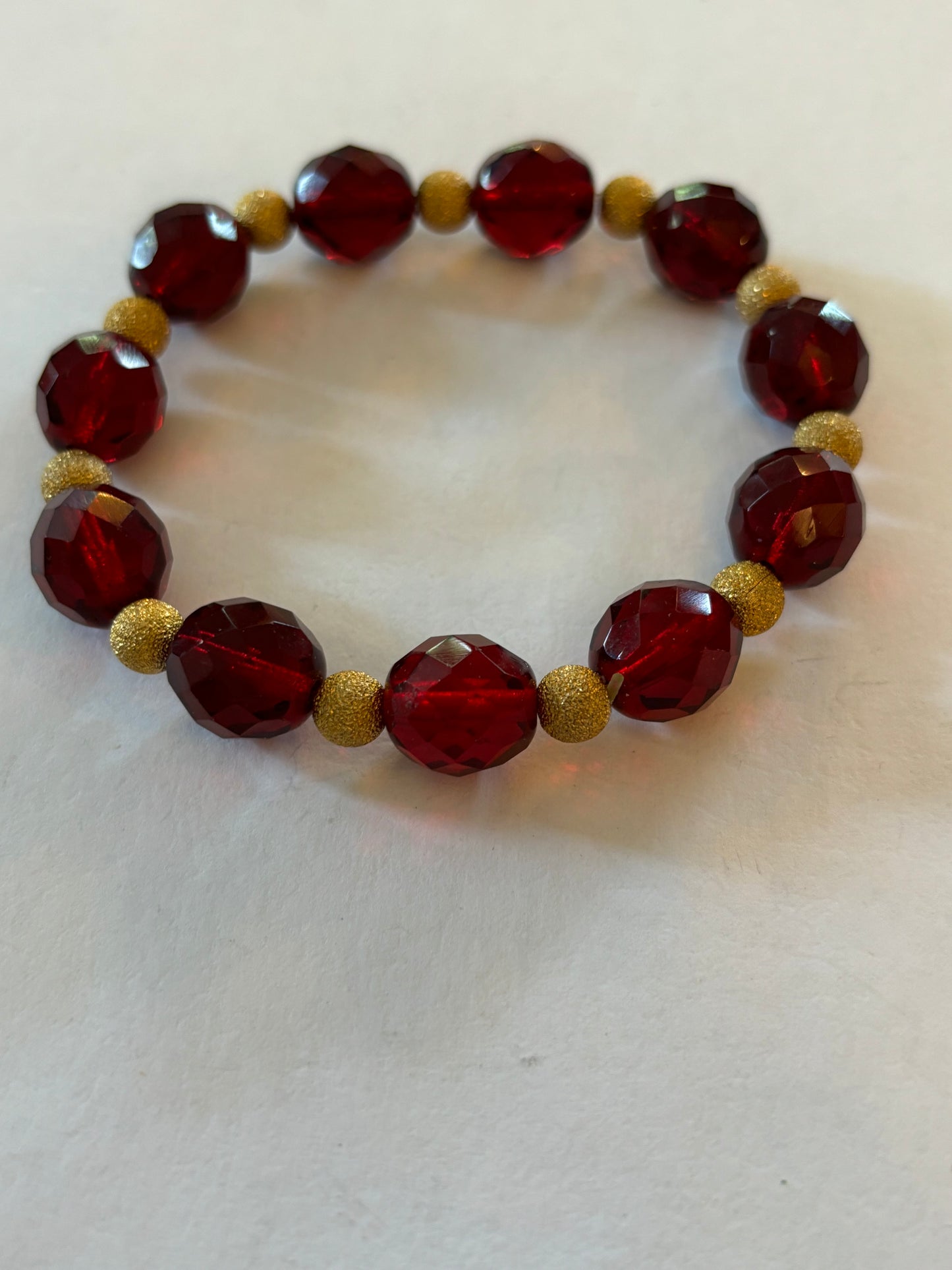 Bright red bead bracelet with gold sparkly spacers