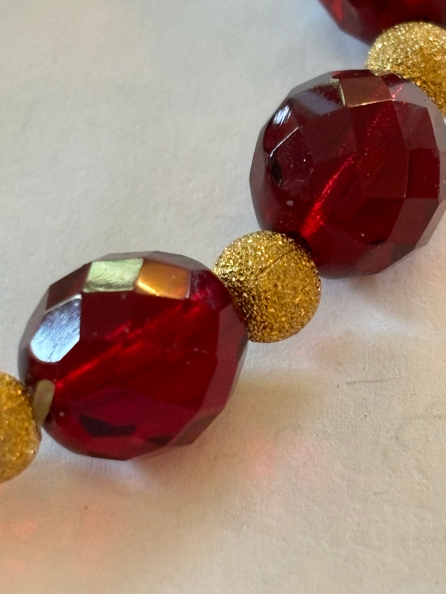 Bright red bead bracelet with gold sparkly spacers