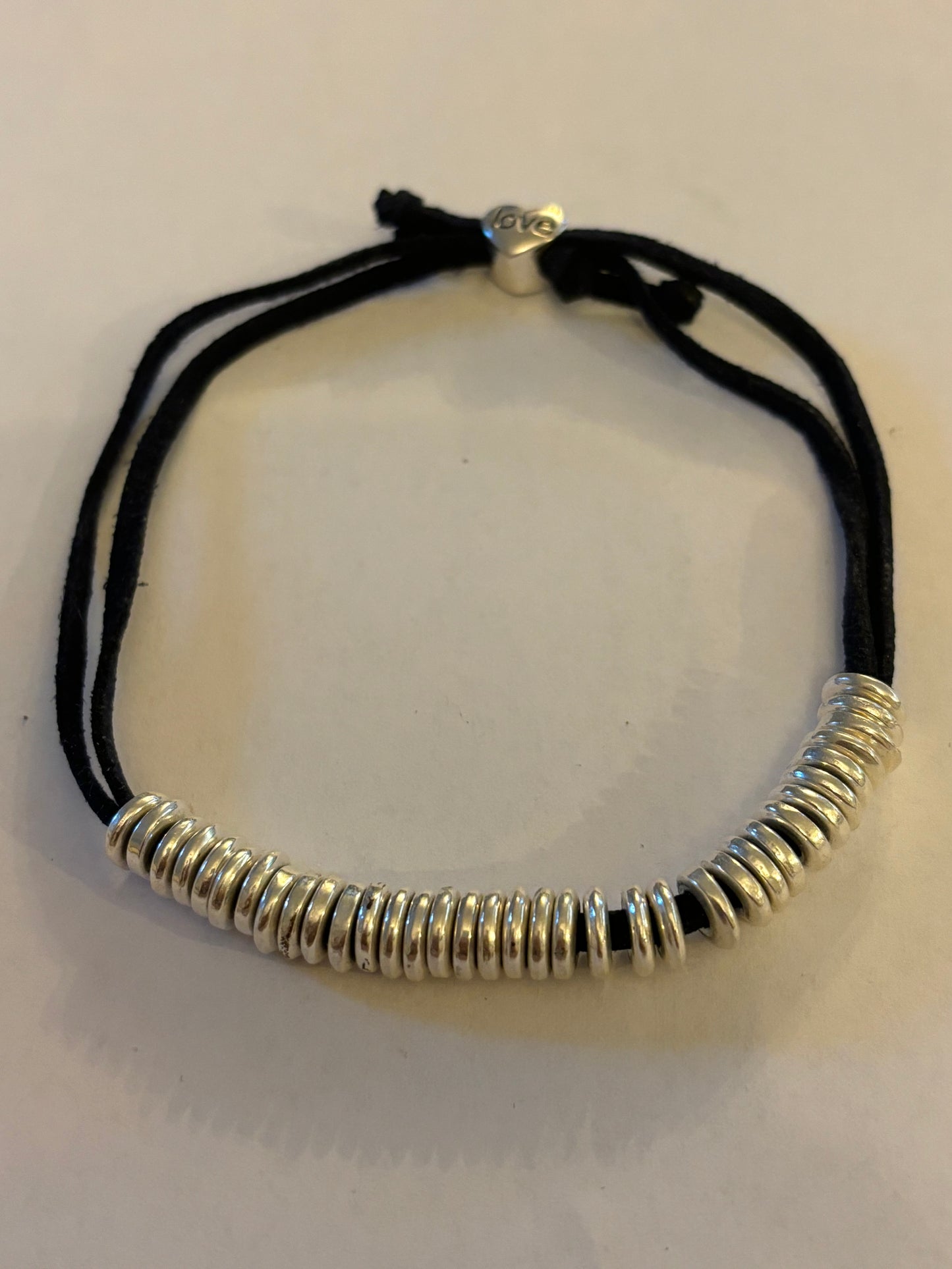 Black string friendship bracelet with silver rings and love bead