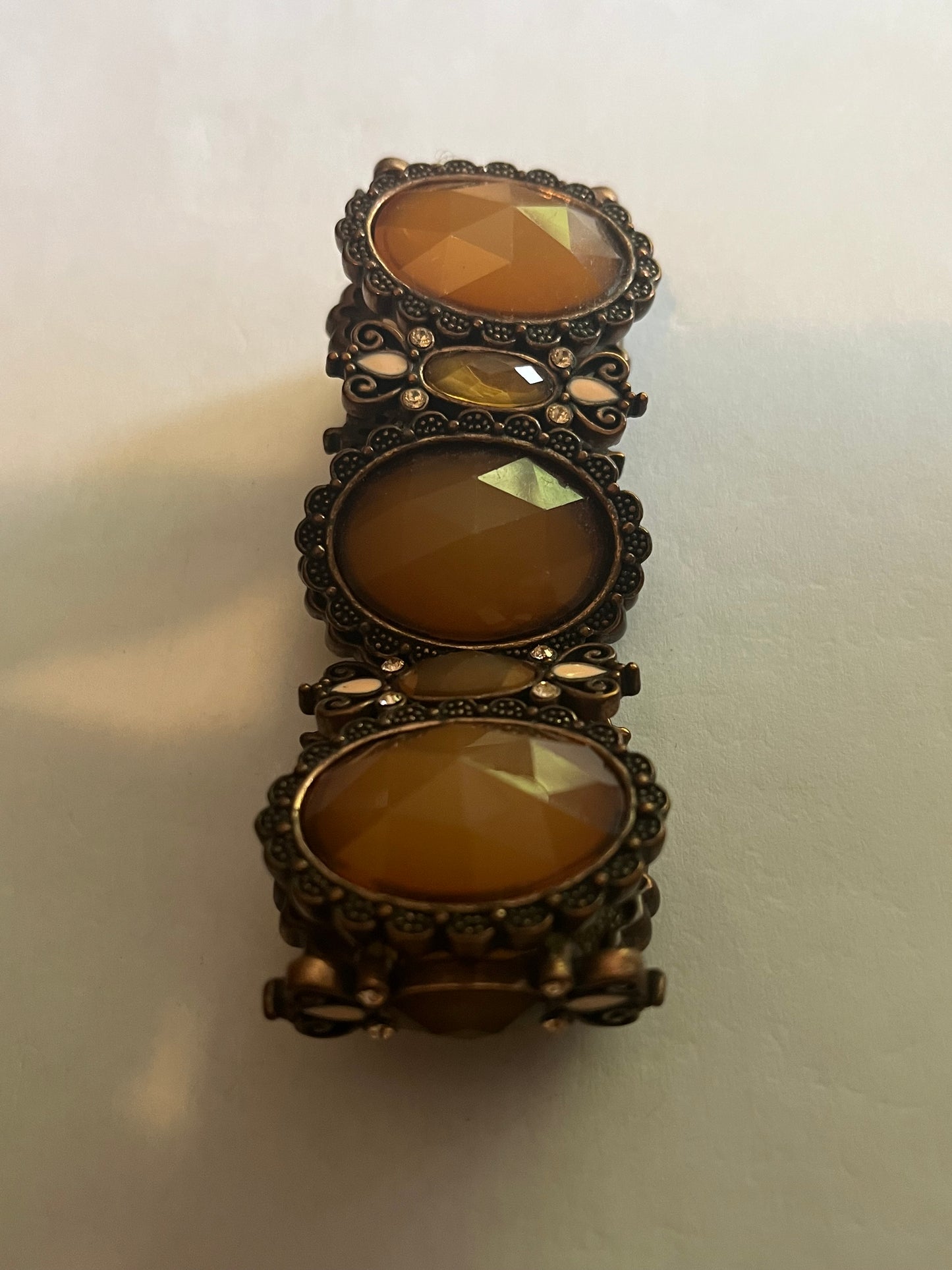 Large bronzey metal dark panel bracelet with oval caramel stones