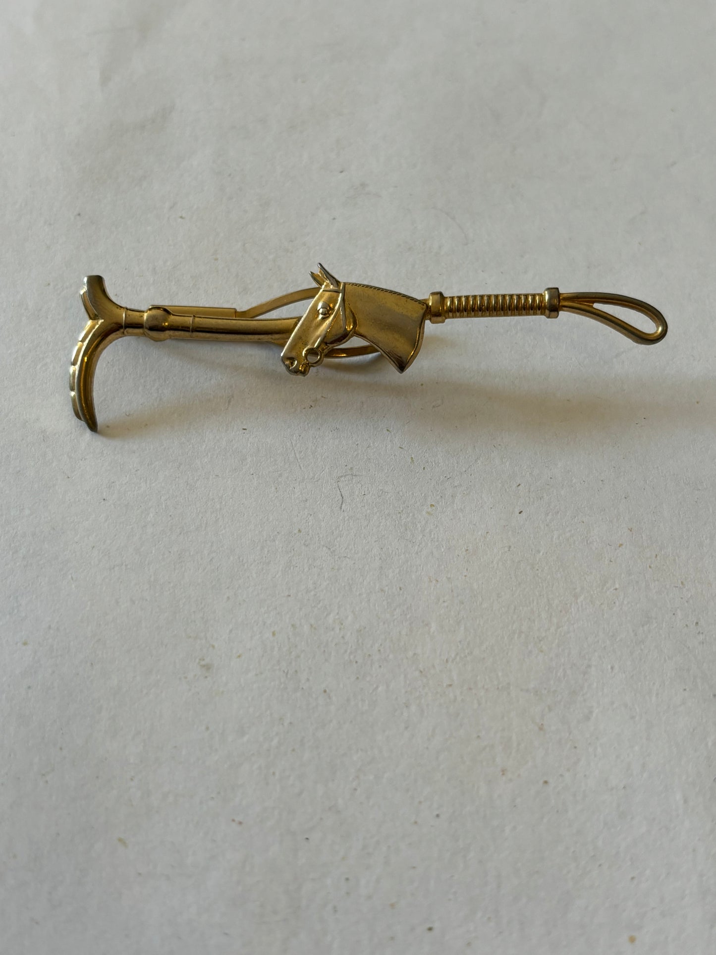 Gold metal horse and riding crop tie clip