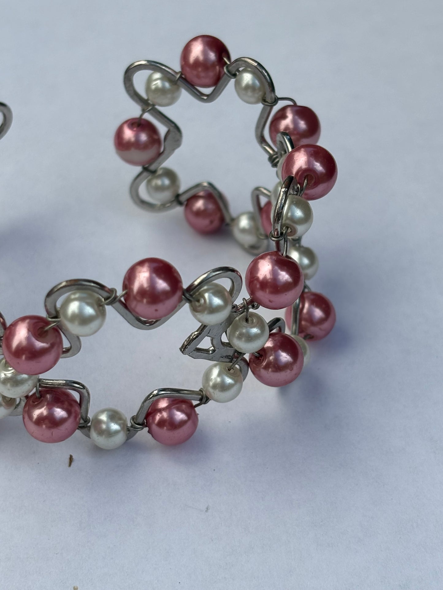 Silver metal star shape bangle with pink and white pearlescent beads