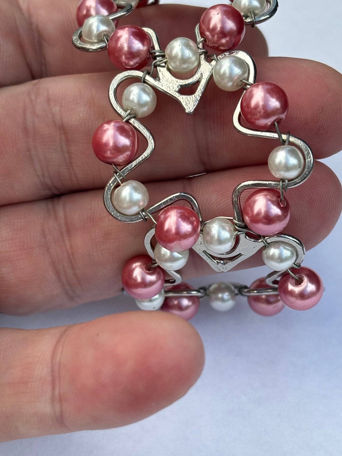 Silver metal star shape bangle with pink and white pearlescent beads