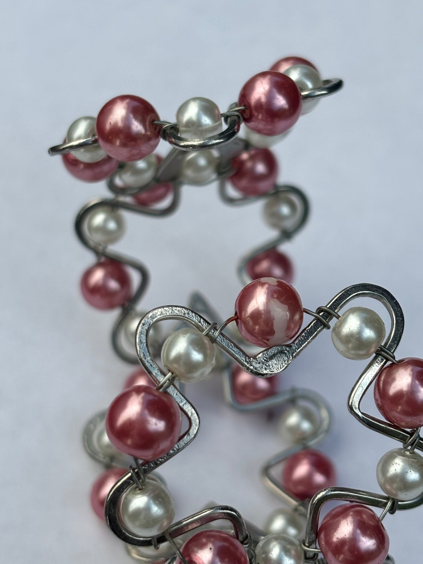 Silver metal star shape bangle with pink and white pearlescent beads