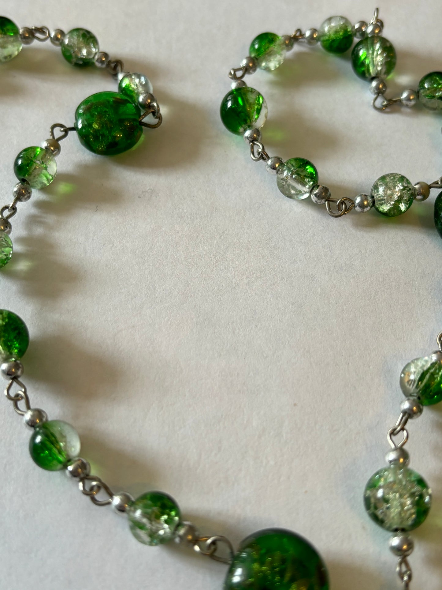 Long silver necklace with green spaced beads