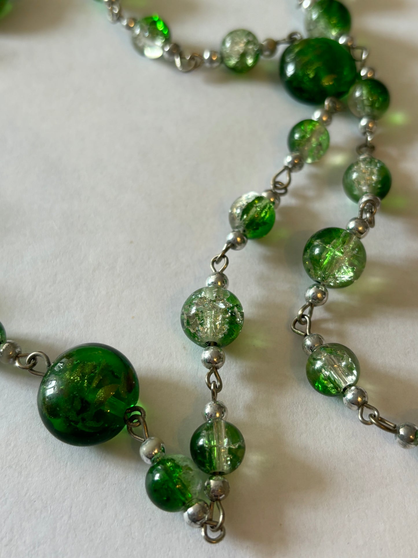 Long silver necklace with green spaced beads