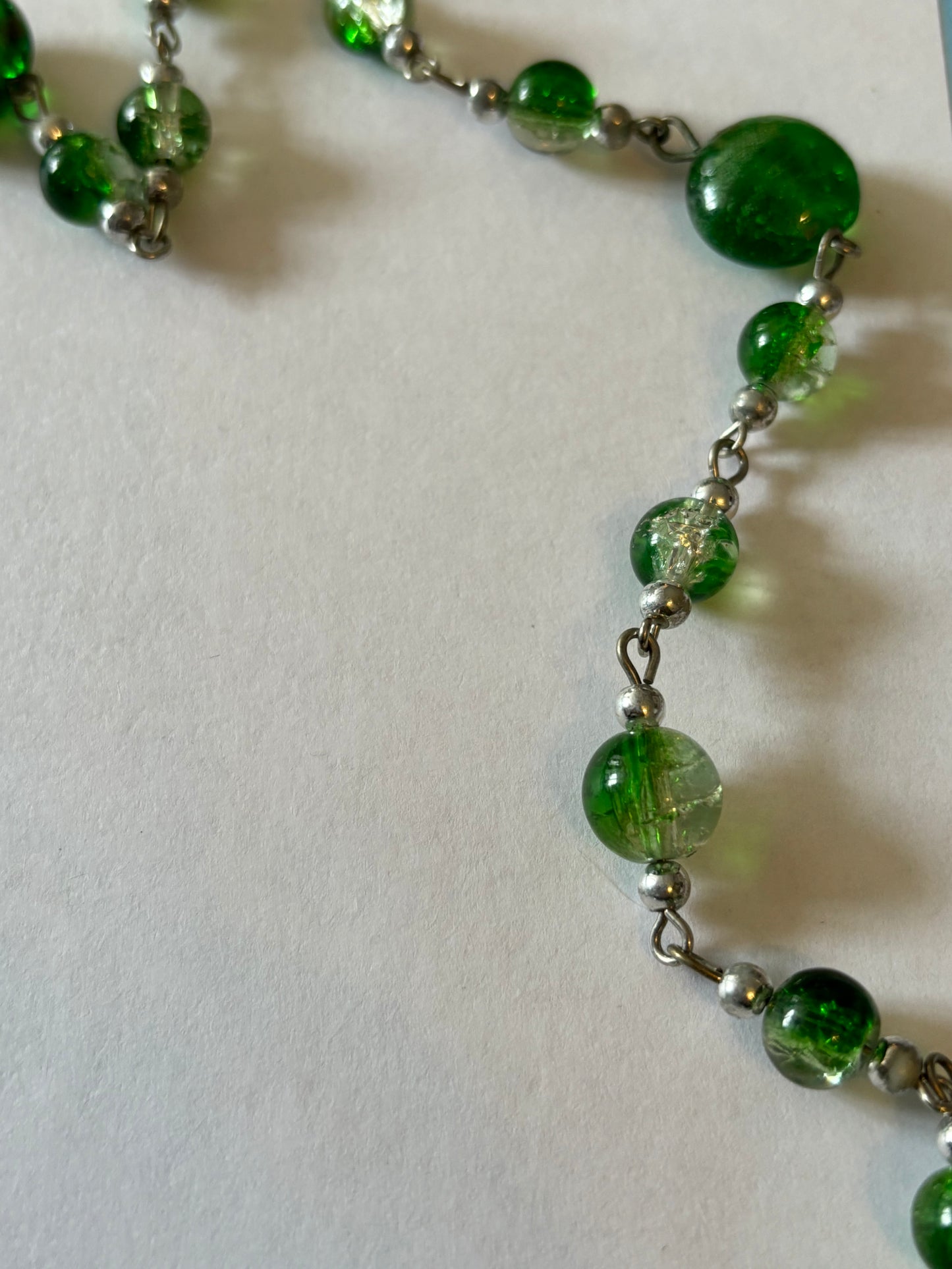 Long silver necklace with green spaced beads